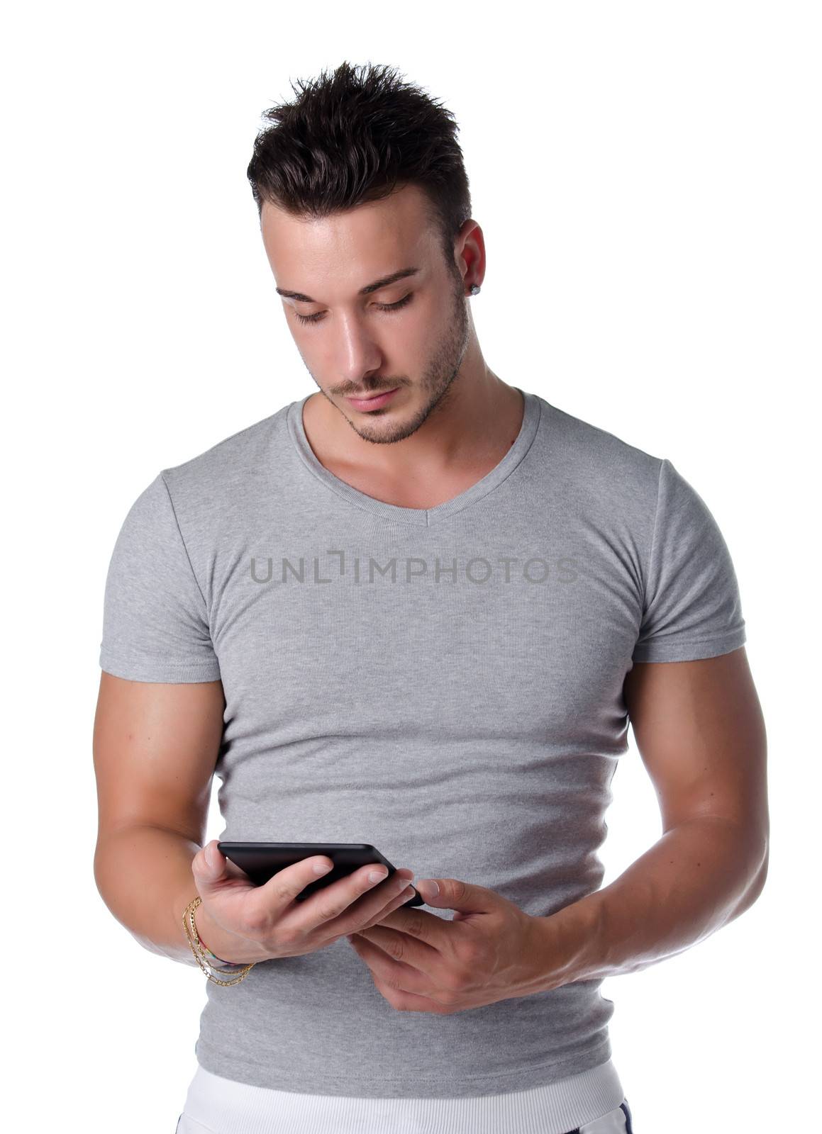 Athletic young man reading book on ebook reader by artofphoto