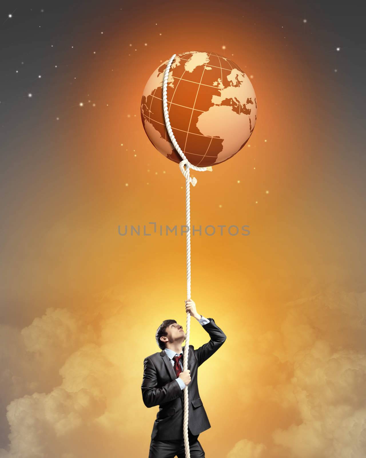 Image of businessman climbing rope attached to earth planet