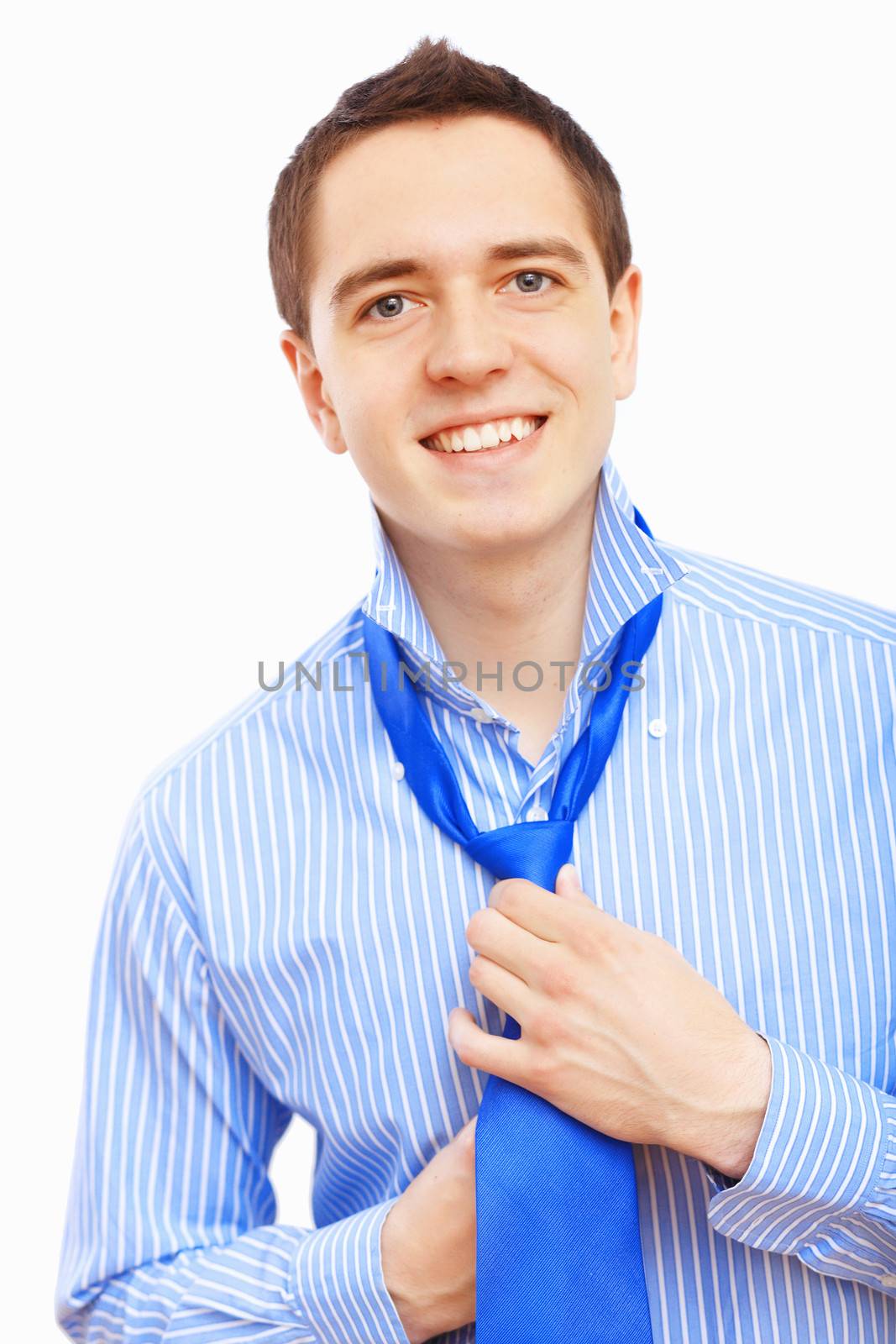 Young businessman at home preparing for a work and making his tie