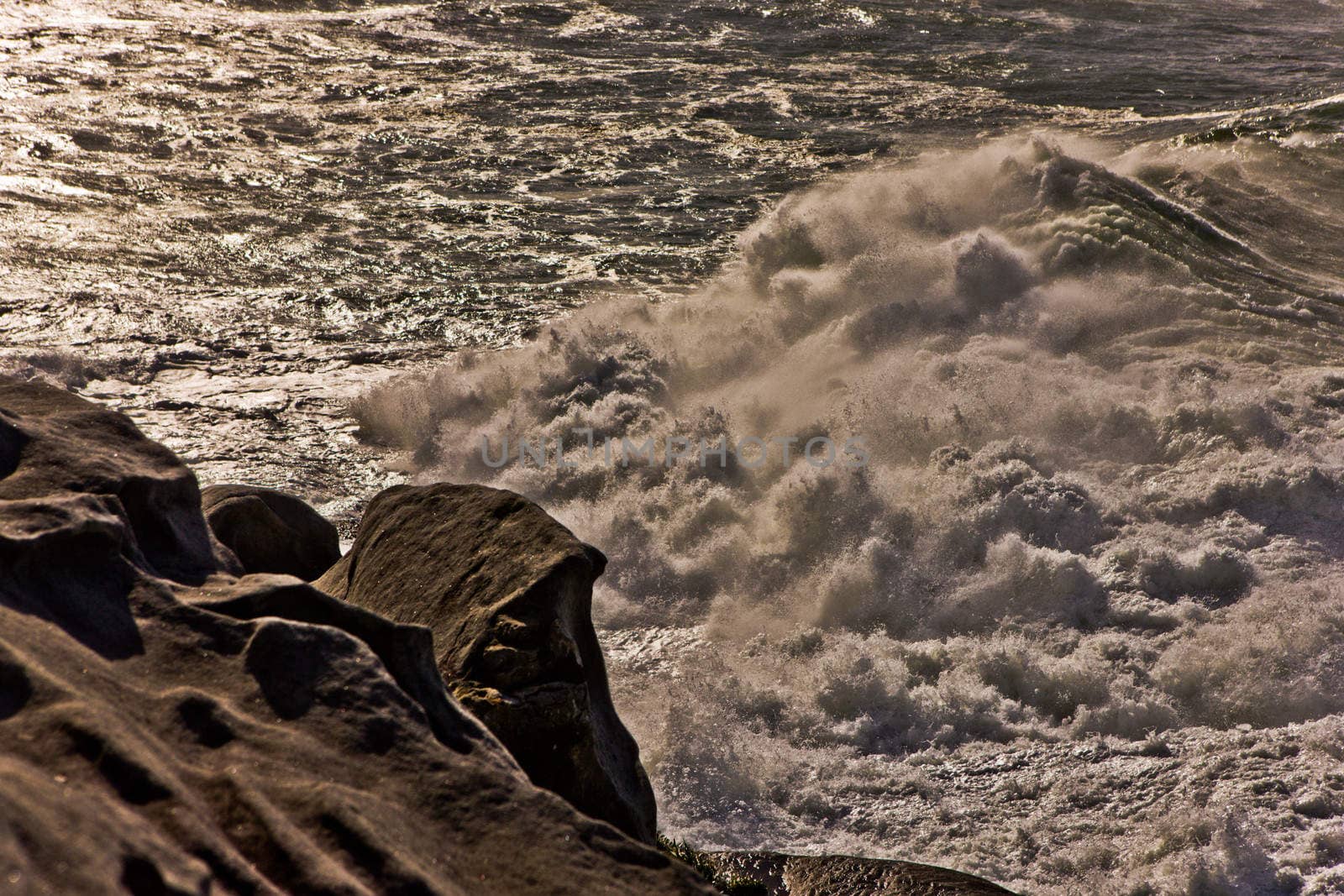 Foamy wave rolling on to the stone in a close up view