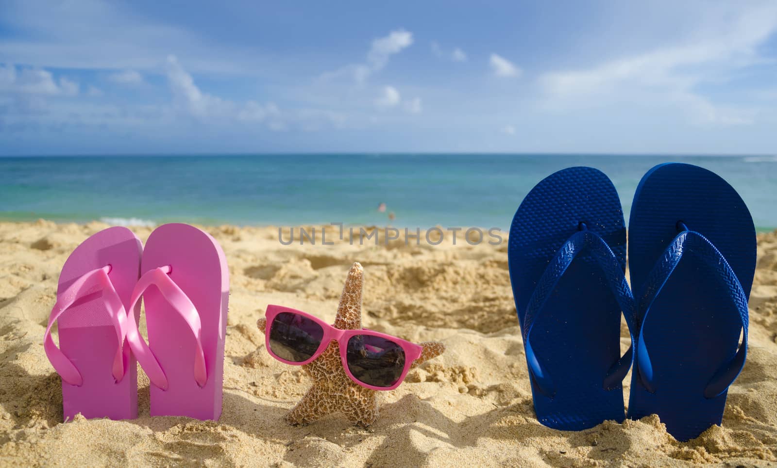 Flip flops and starfish with sunglasses on sandy beach by EllenSmile