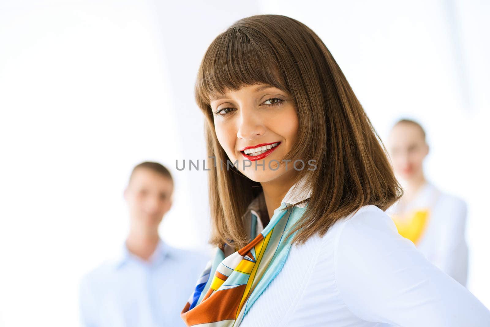 Portrait of a young successful business woman standing against colleagues