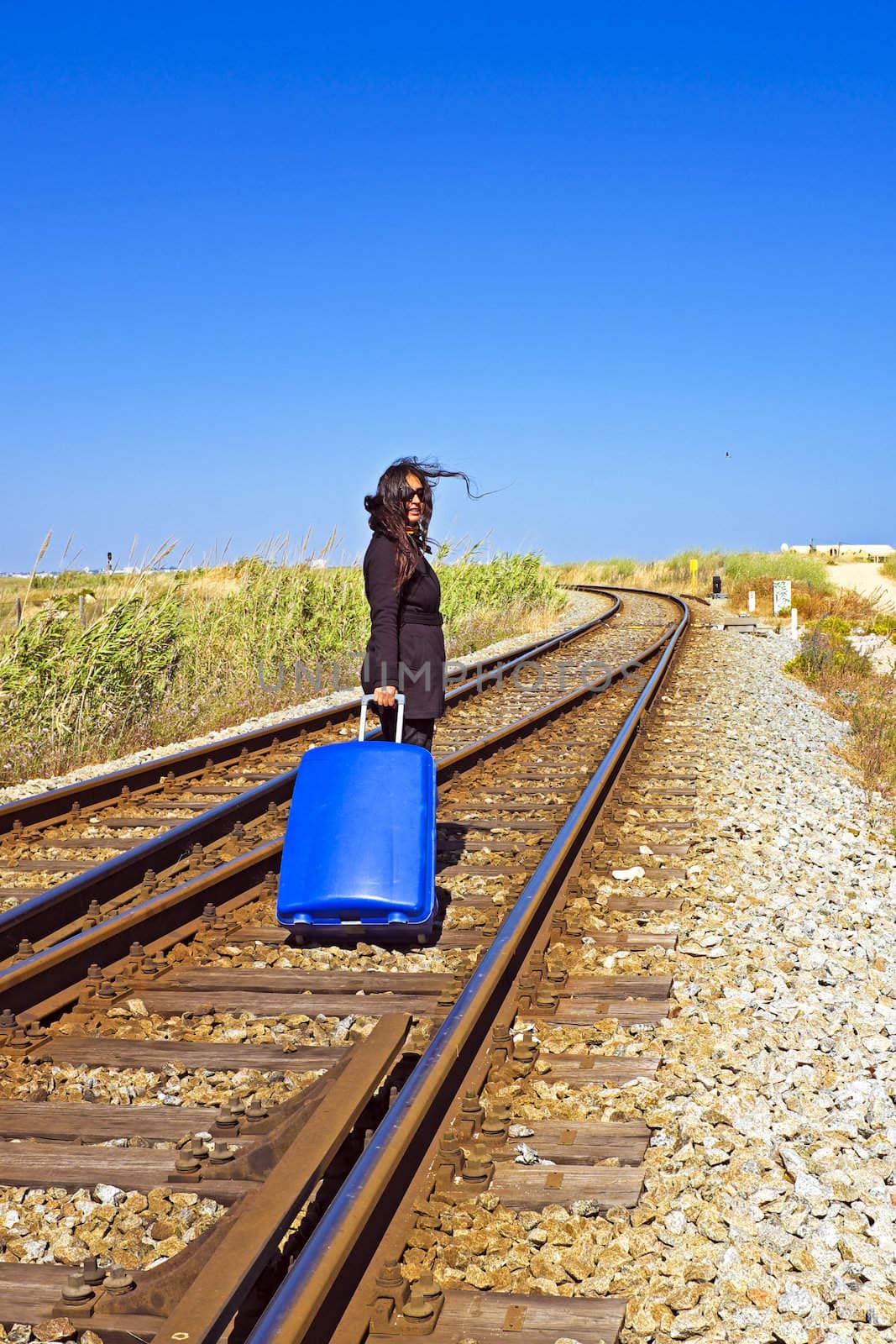 Young woman with her suitcase on a railroad track by devy