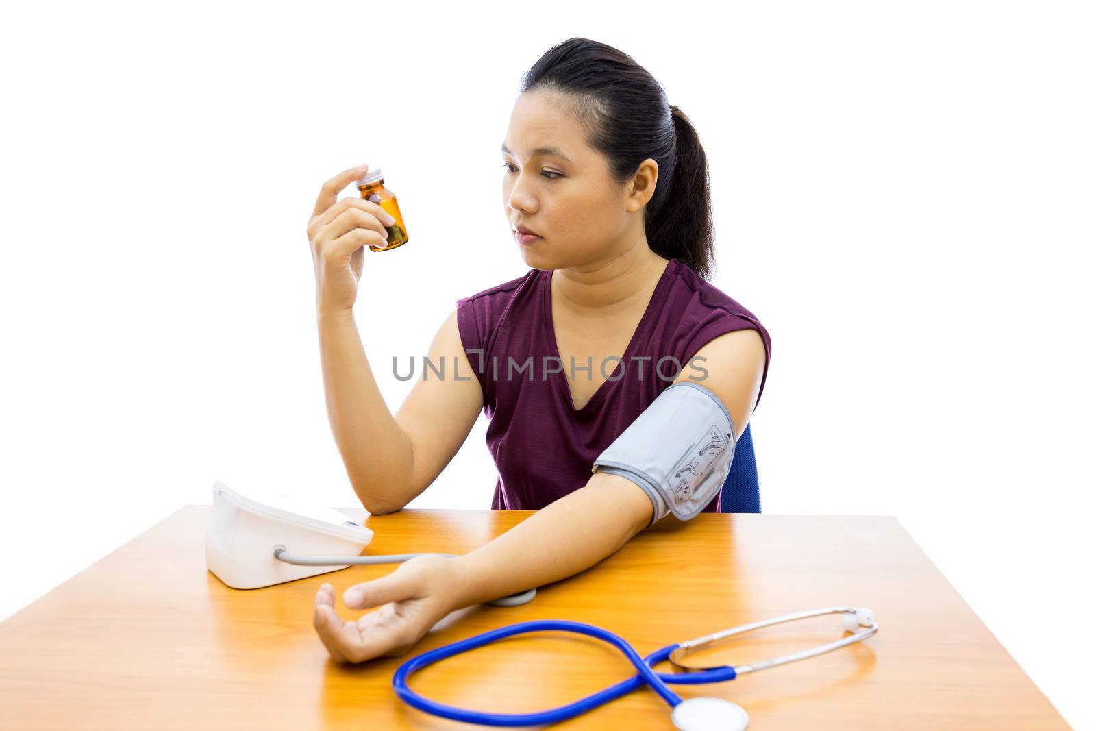 Young adult woman unhappy with her self blood pressure test (Selective focus at woman)