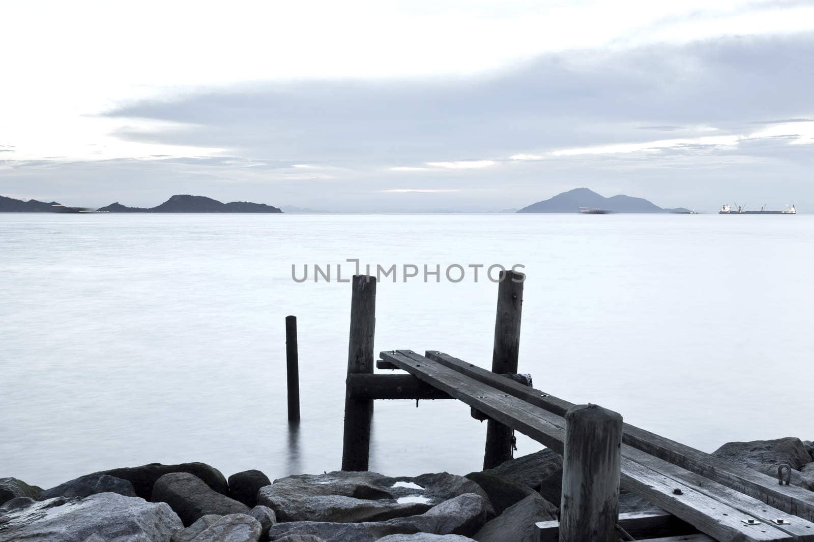 Clam sunset with jetty on sea