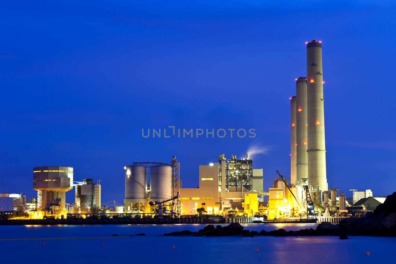 Smoking industrial power plant at night 