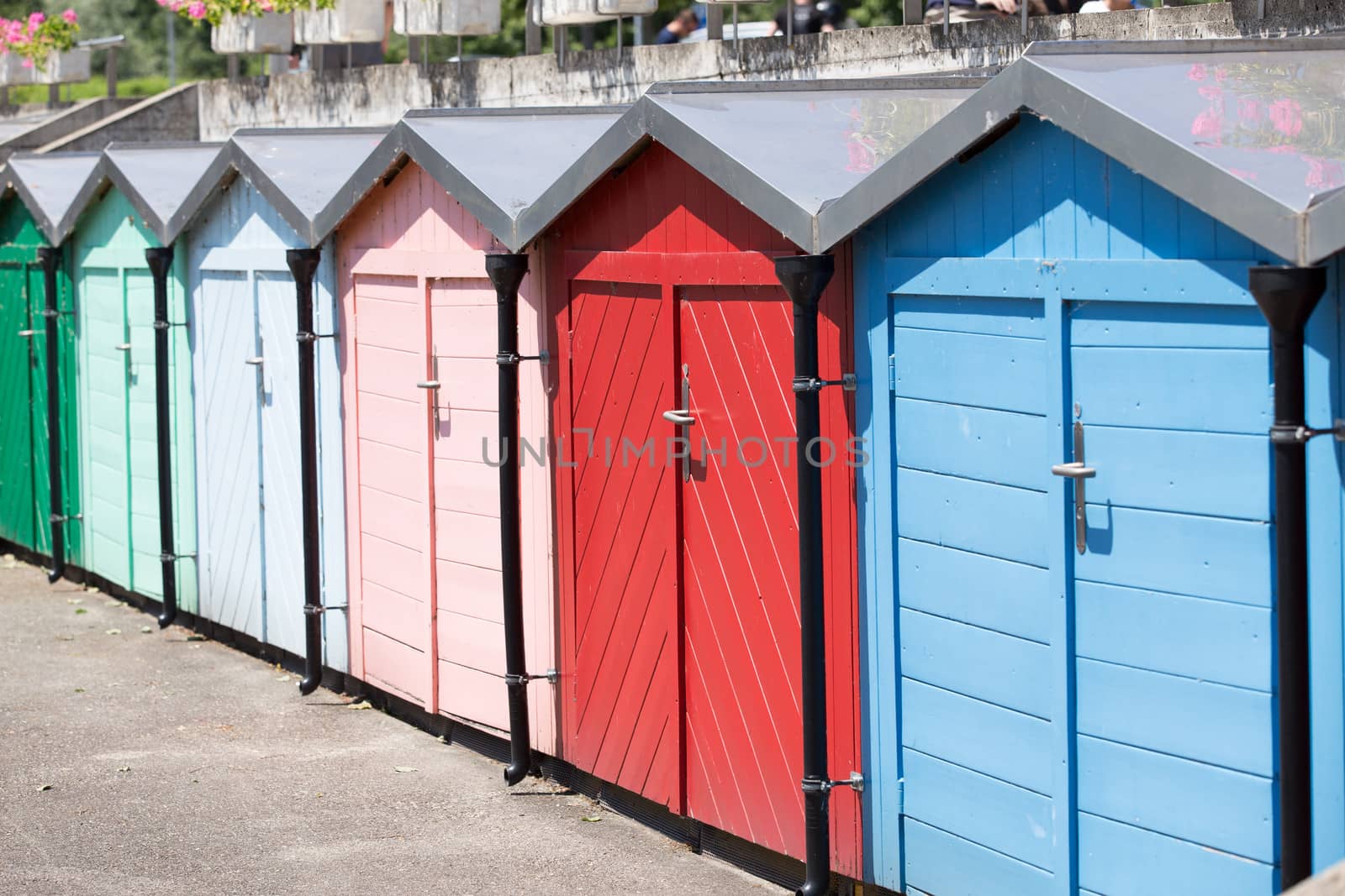 Row of colored beach huts in sunny day.