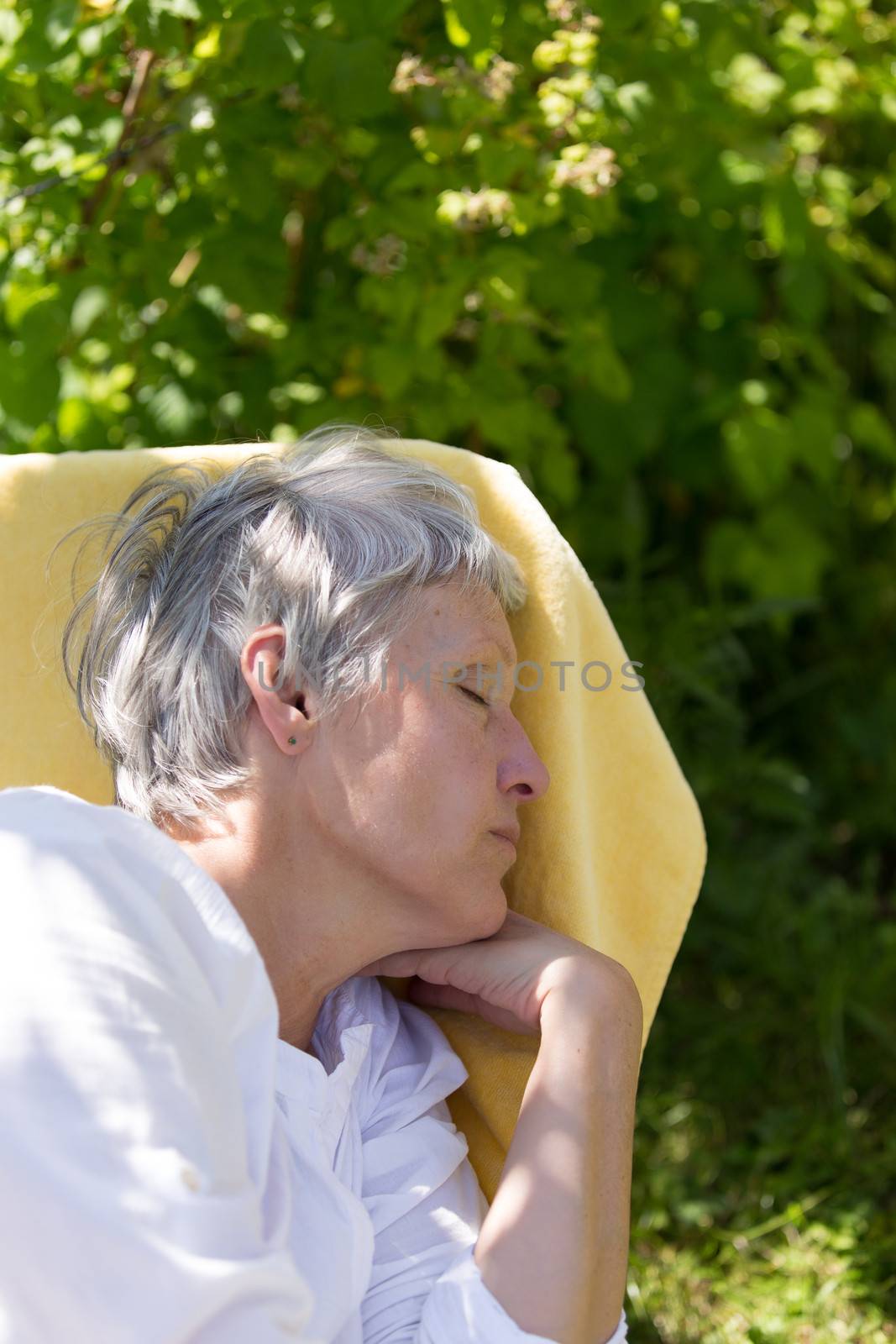 Aged woman sleeping on lounger by lusjen_n