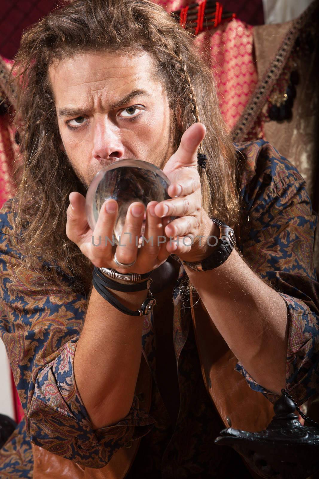 Serious Gypsy man coddling a crystal ball