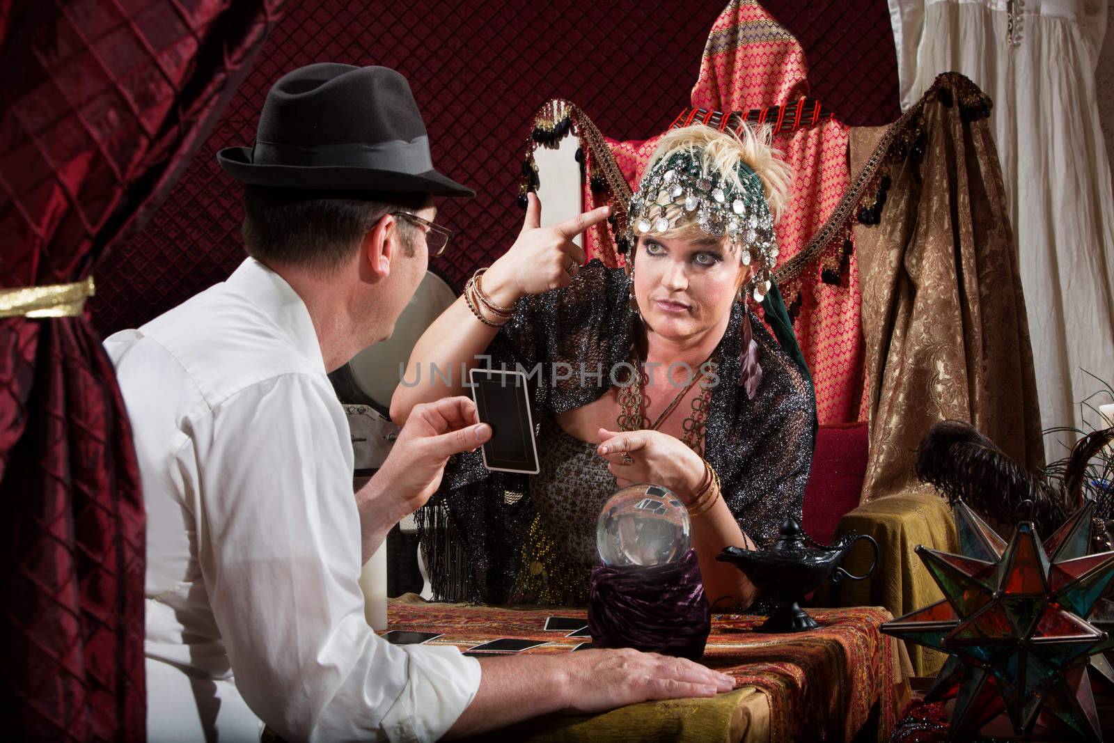 Fortune teller gesturing a gun to her head with customer