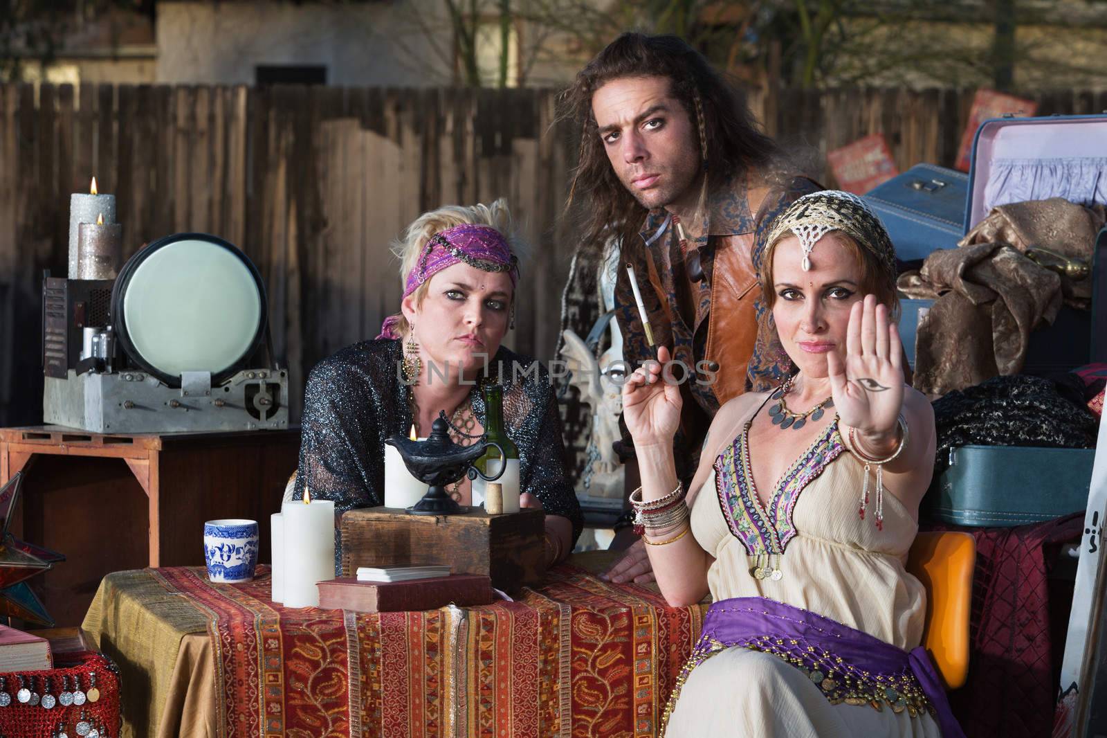 Sexy palm reader showing the evil eye as friends look on
