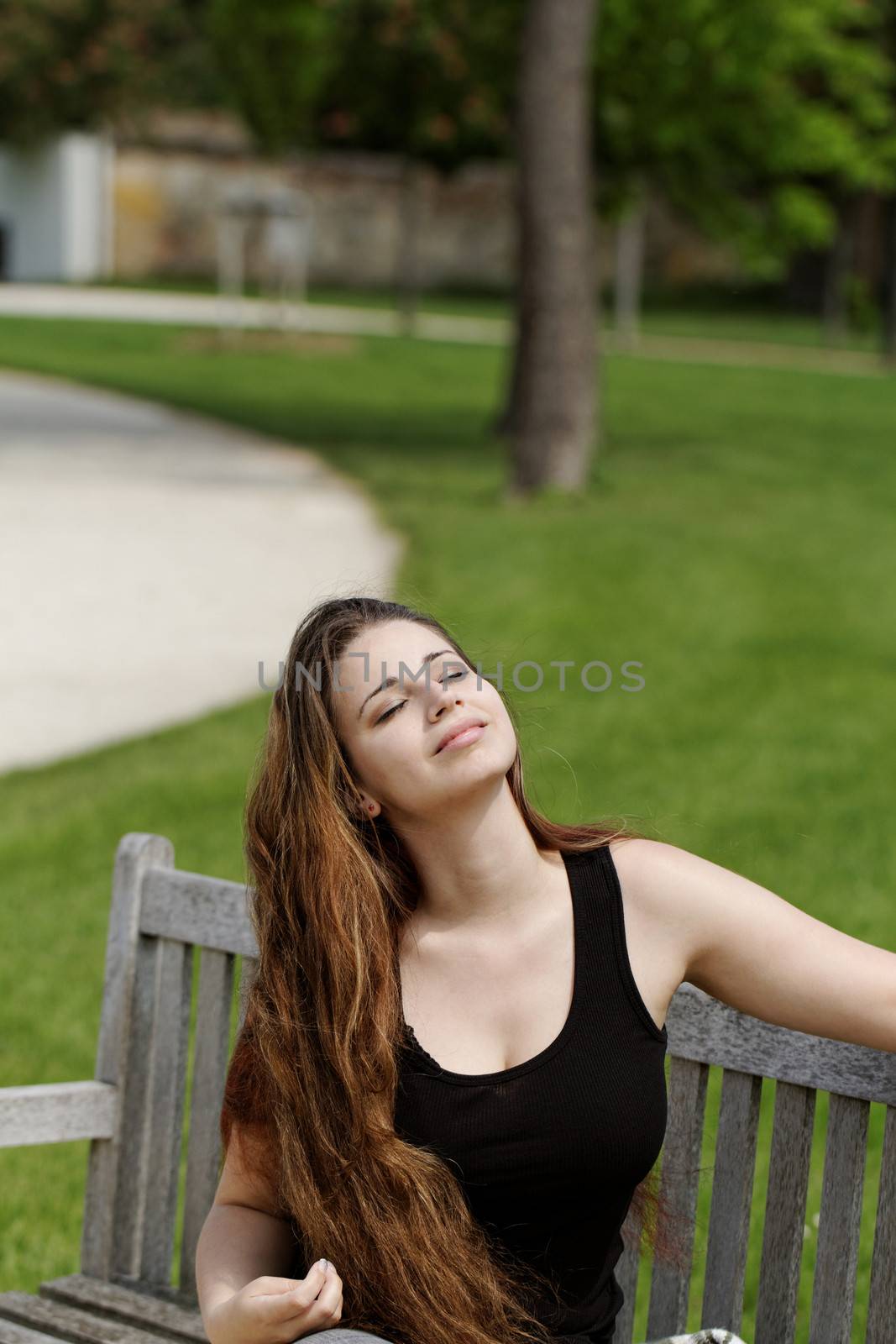 pretty young girl sunbathing on a bench