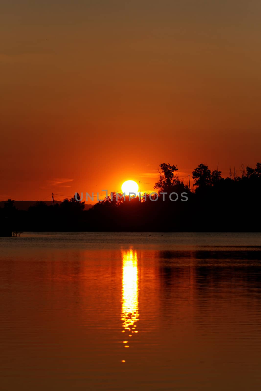 Colorful sunset over tranquil water surface.