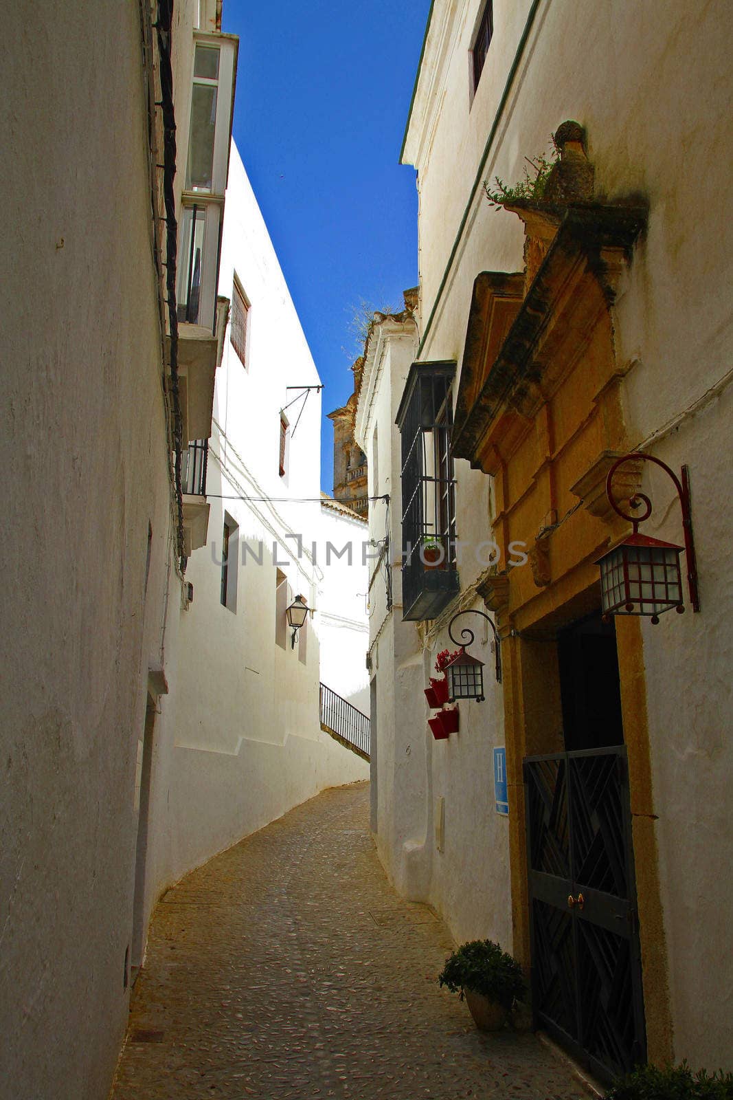 Old, traditional houses on a narrow passage in the ancient village of Arcos de la Frontera in Andalucia, Spain