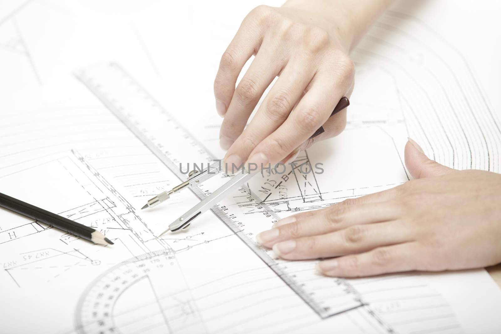 Hands of engineer working on a construction plan