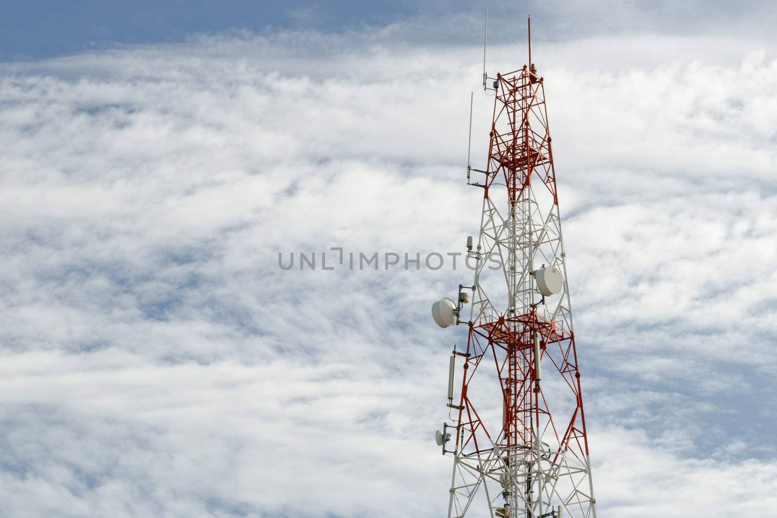 Telecommunication mast with microwave link and TV transmitter antennas over a blue sky