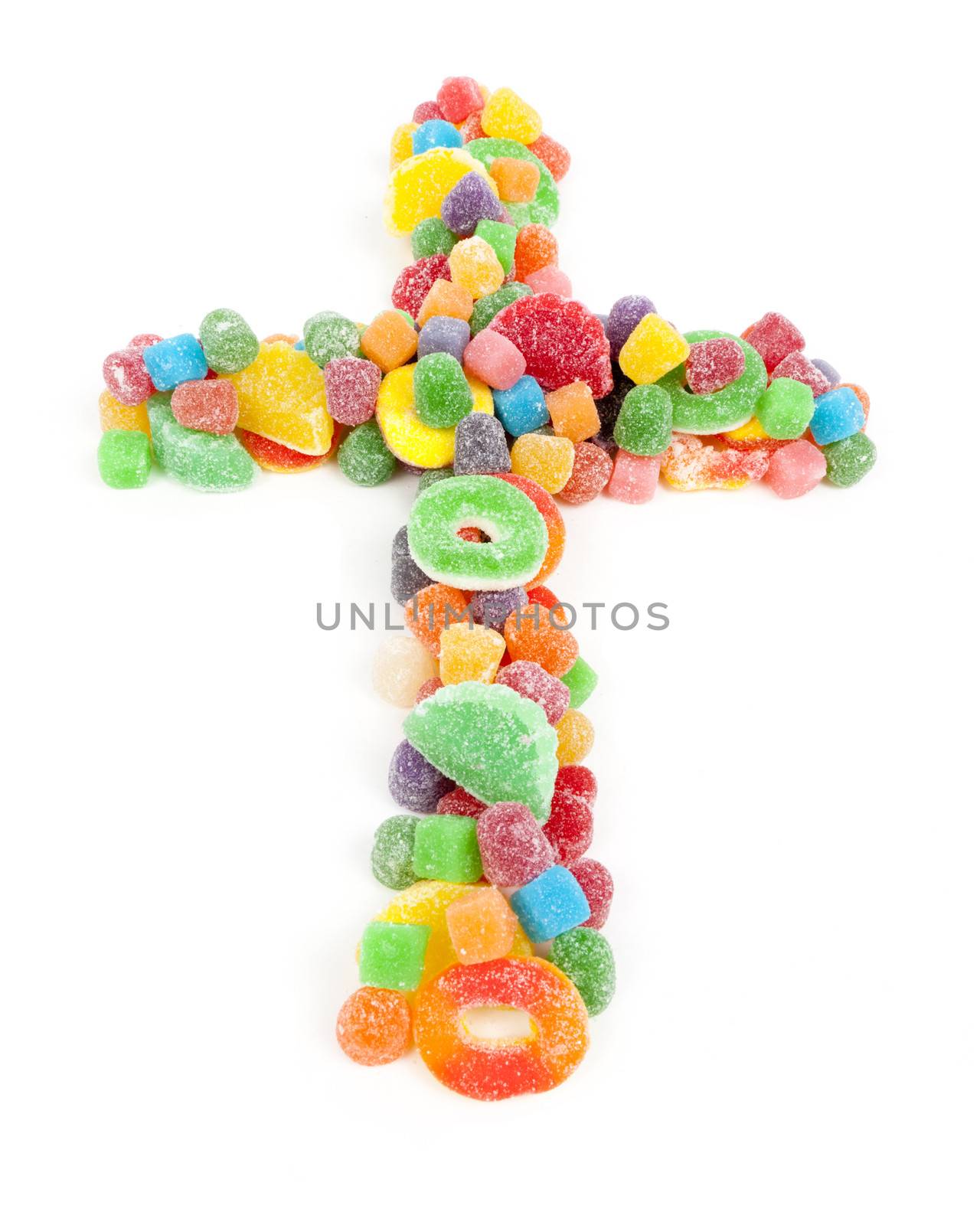 A Christian cross made of sugared gummy candy against a white background.