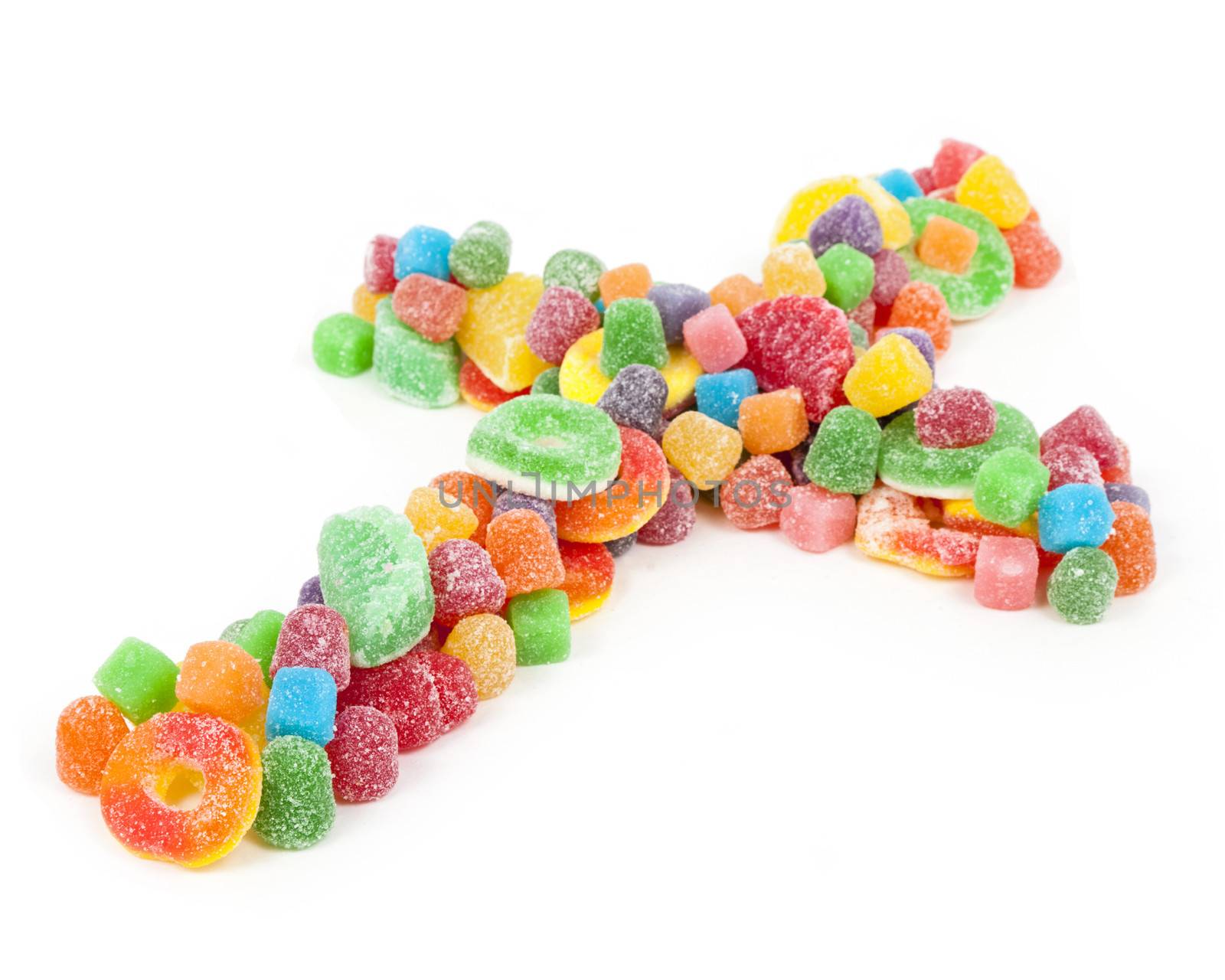 A Christian cross made of sugared gummy candy against a white background.