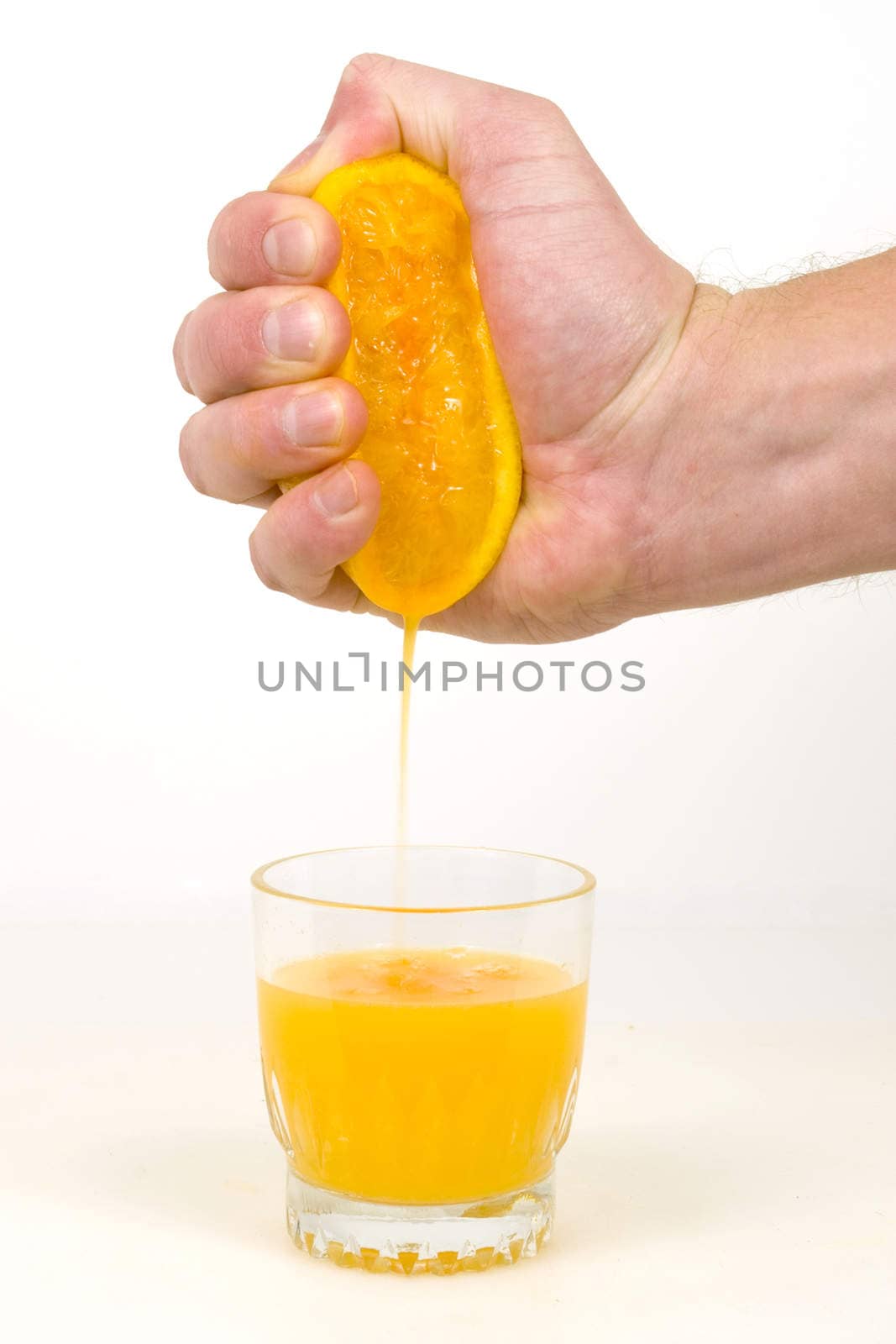 A male hand squeezes an orange into juice.