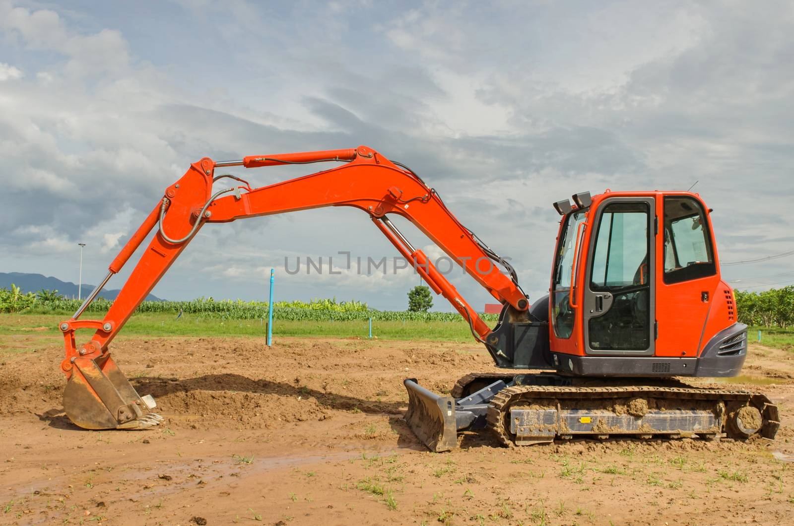 red excavator working in the farmland