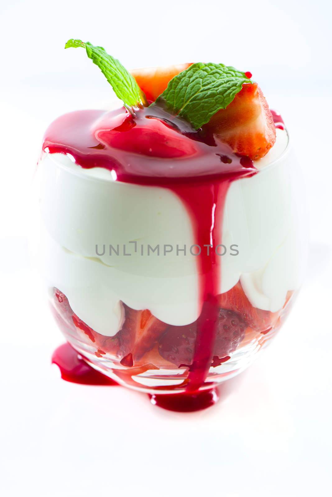 Sweet dessert strawberry and cream in a glass on white background