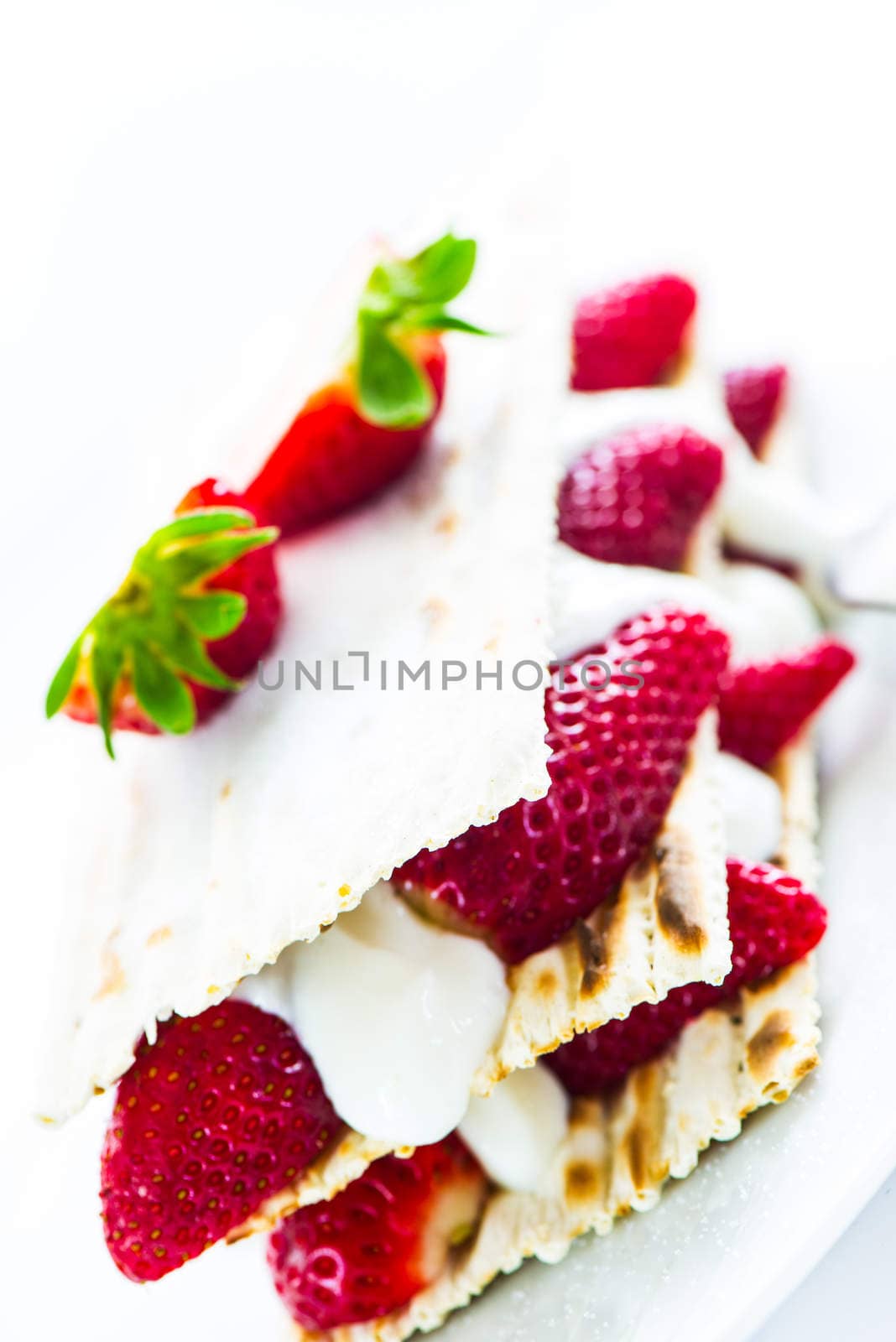 small strawberry cake with cream on white background