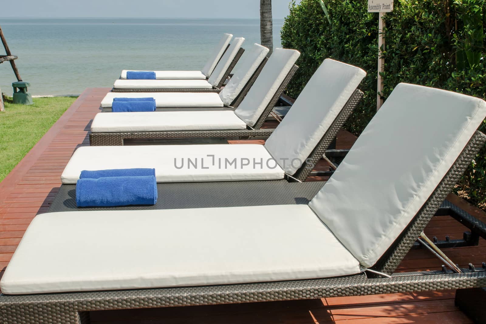 empty white sunbed with wrapped towels