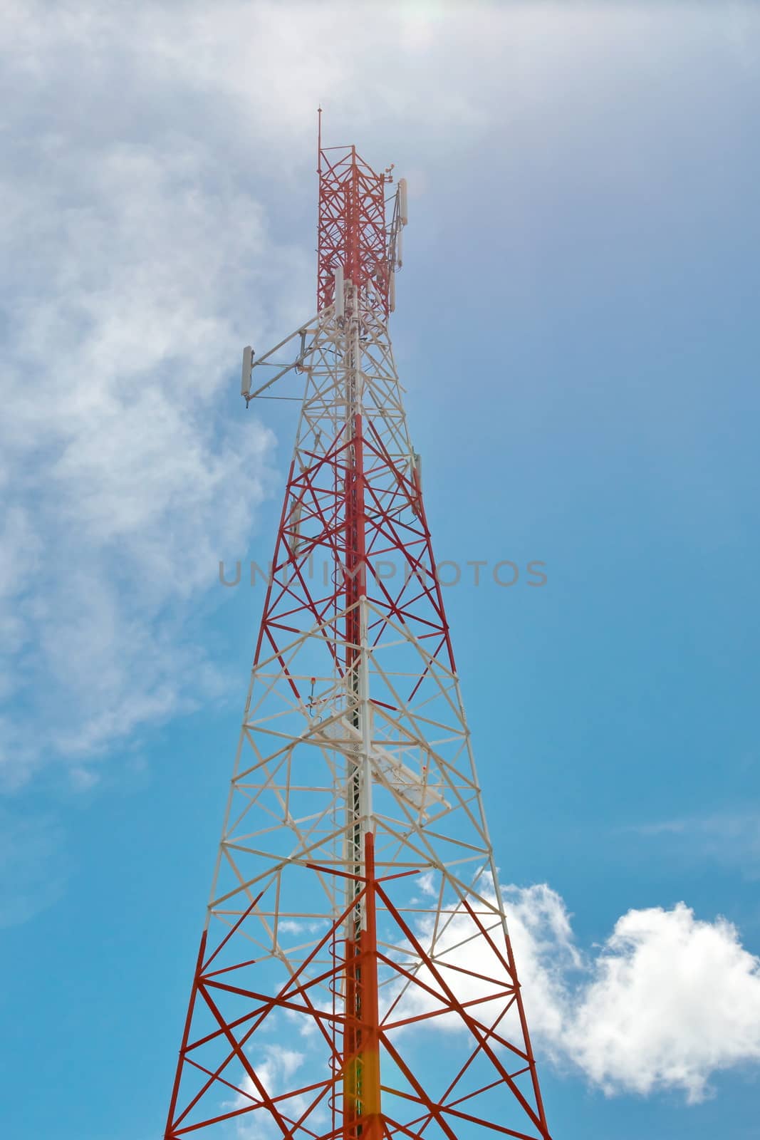 Telecommunication mast with microwave link and TV transmitter antennas over a blue sky