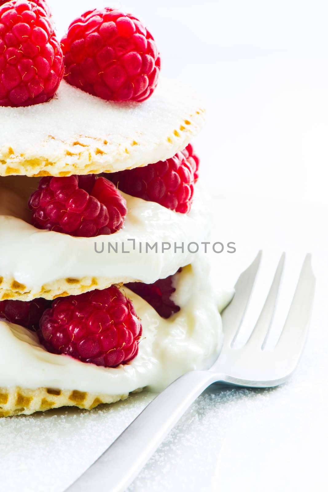 small raspberry cake with cream on white background