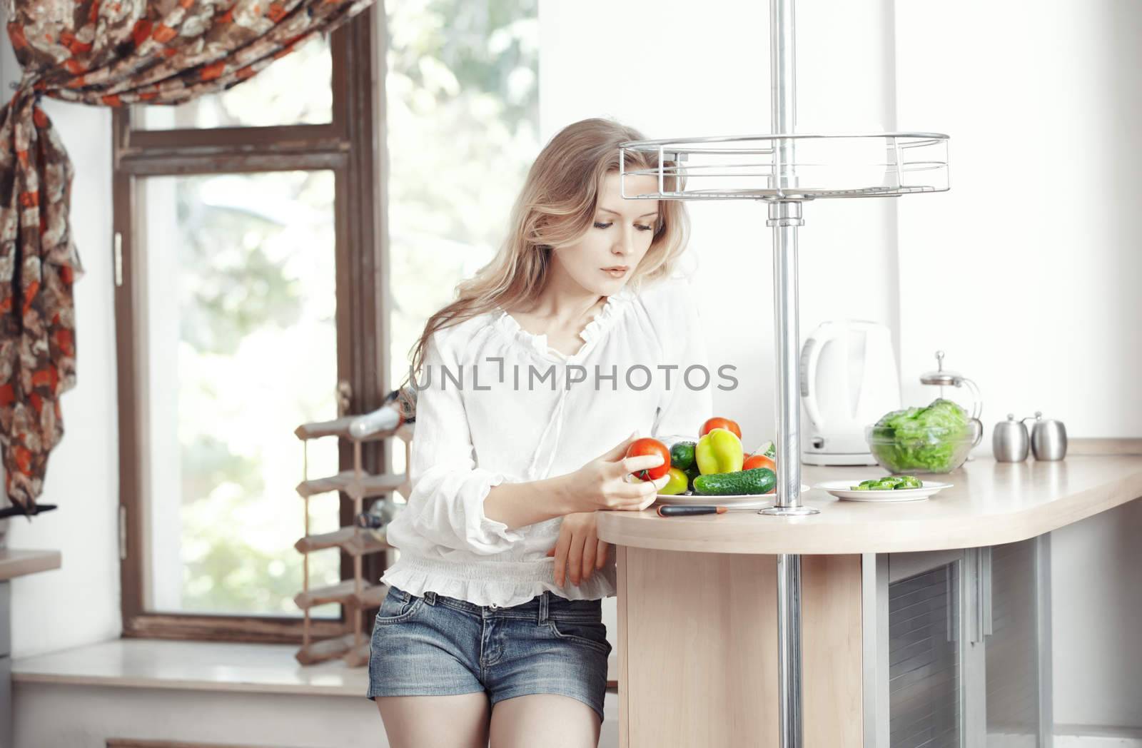 Blond lady at kitchen preparing vegetable for breakfast