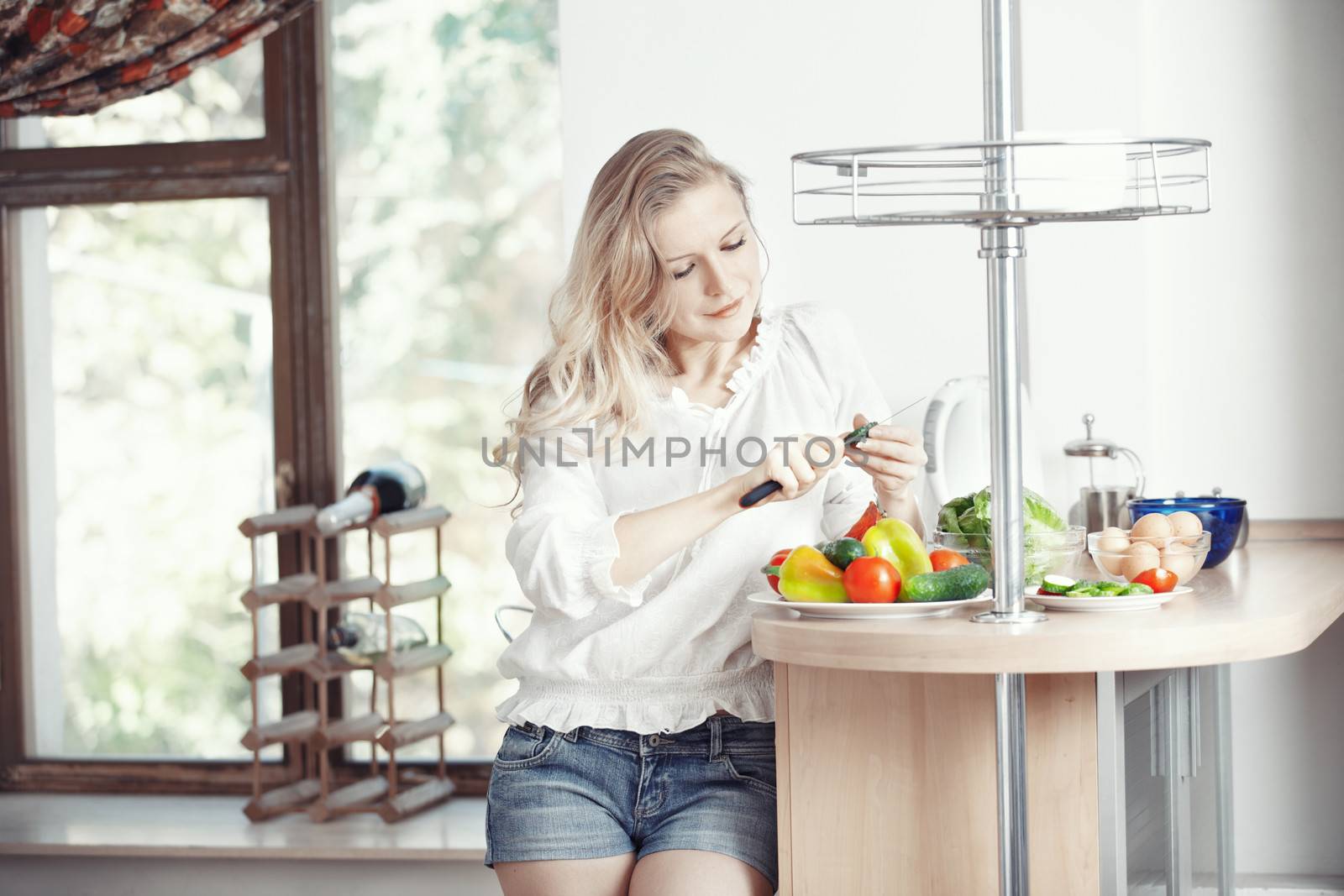 Blond lady at kitchen preparing vegetable for breakfast