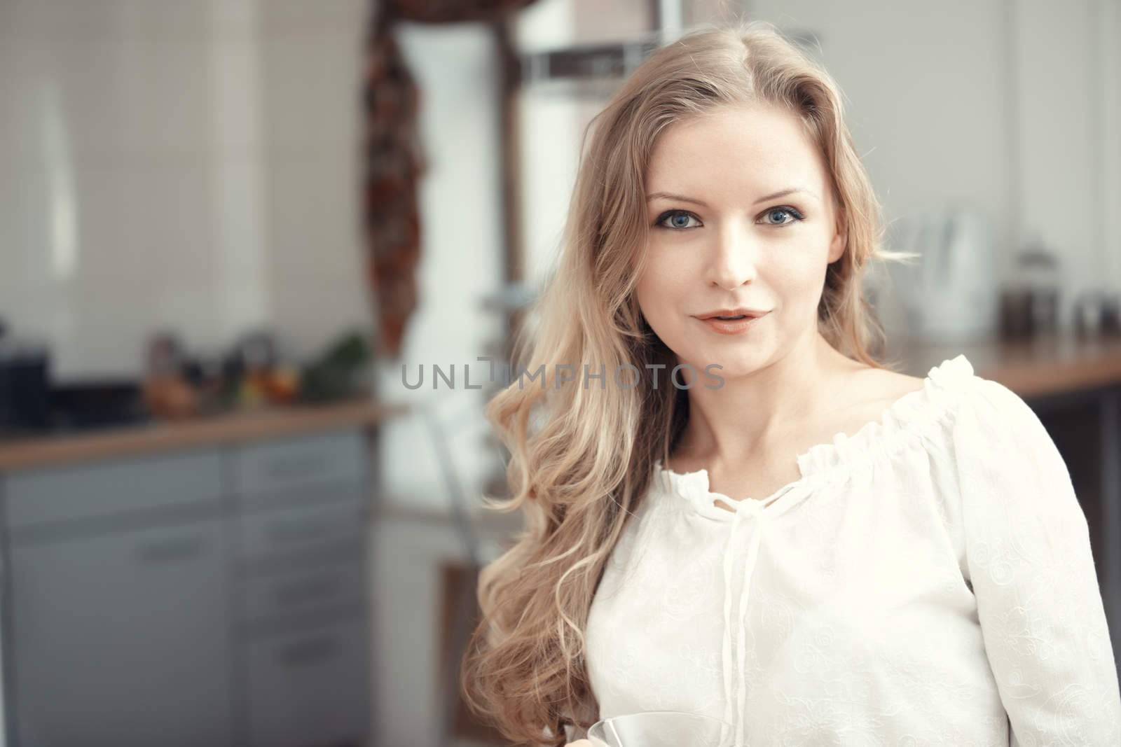 Blond lady indoors at her kitchen