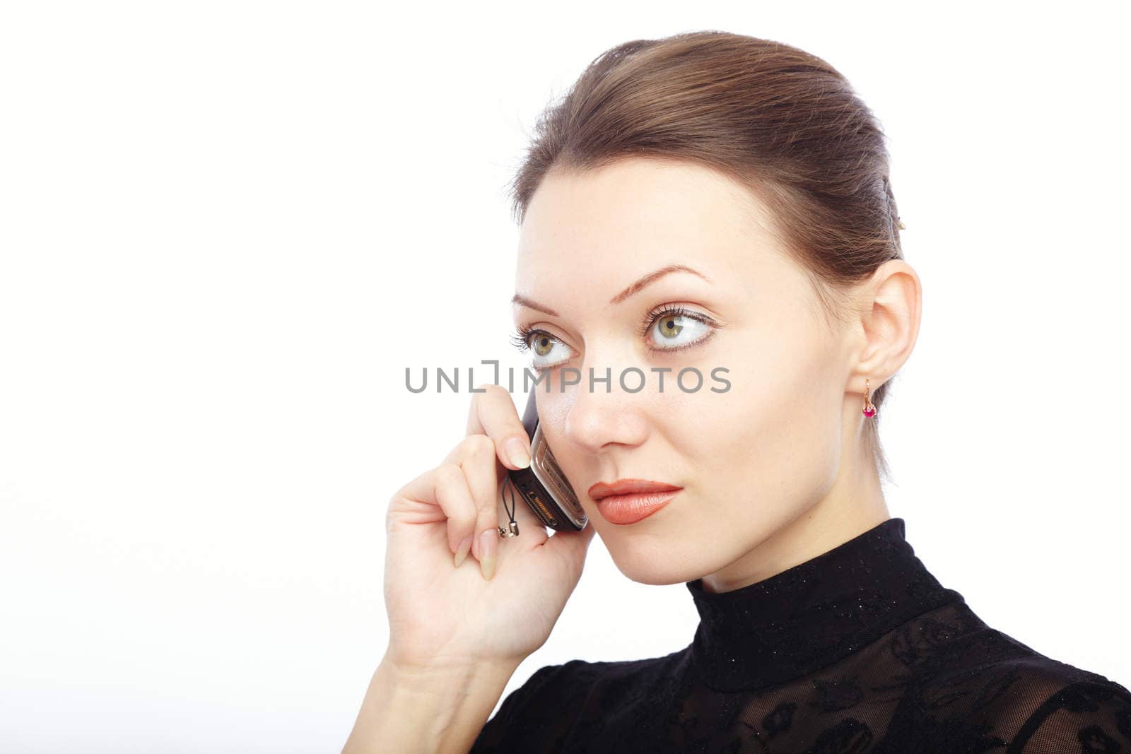 Serious lady on a white background talking via cellphone
