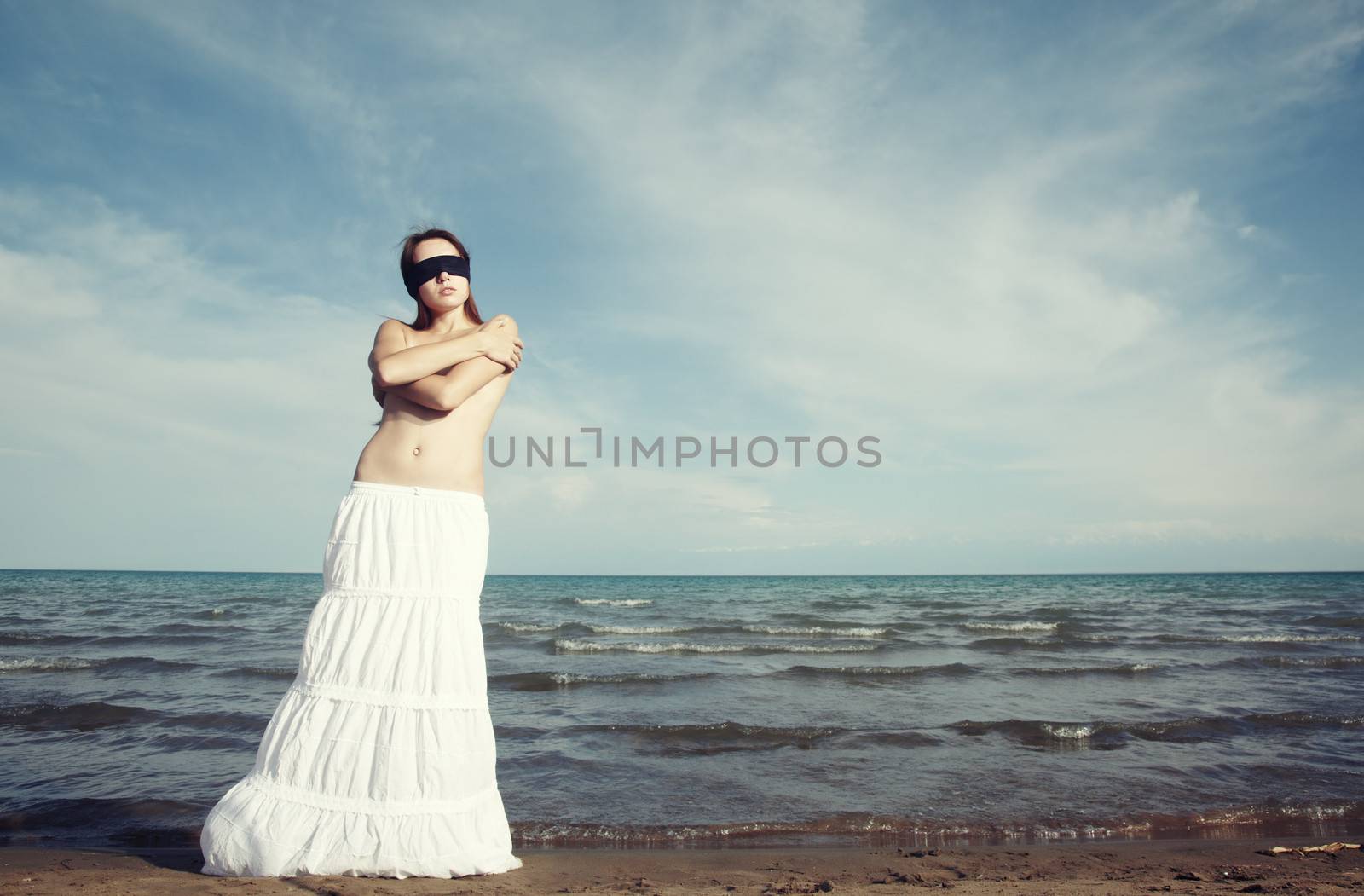 Lady with blindfold stands at the beach