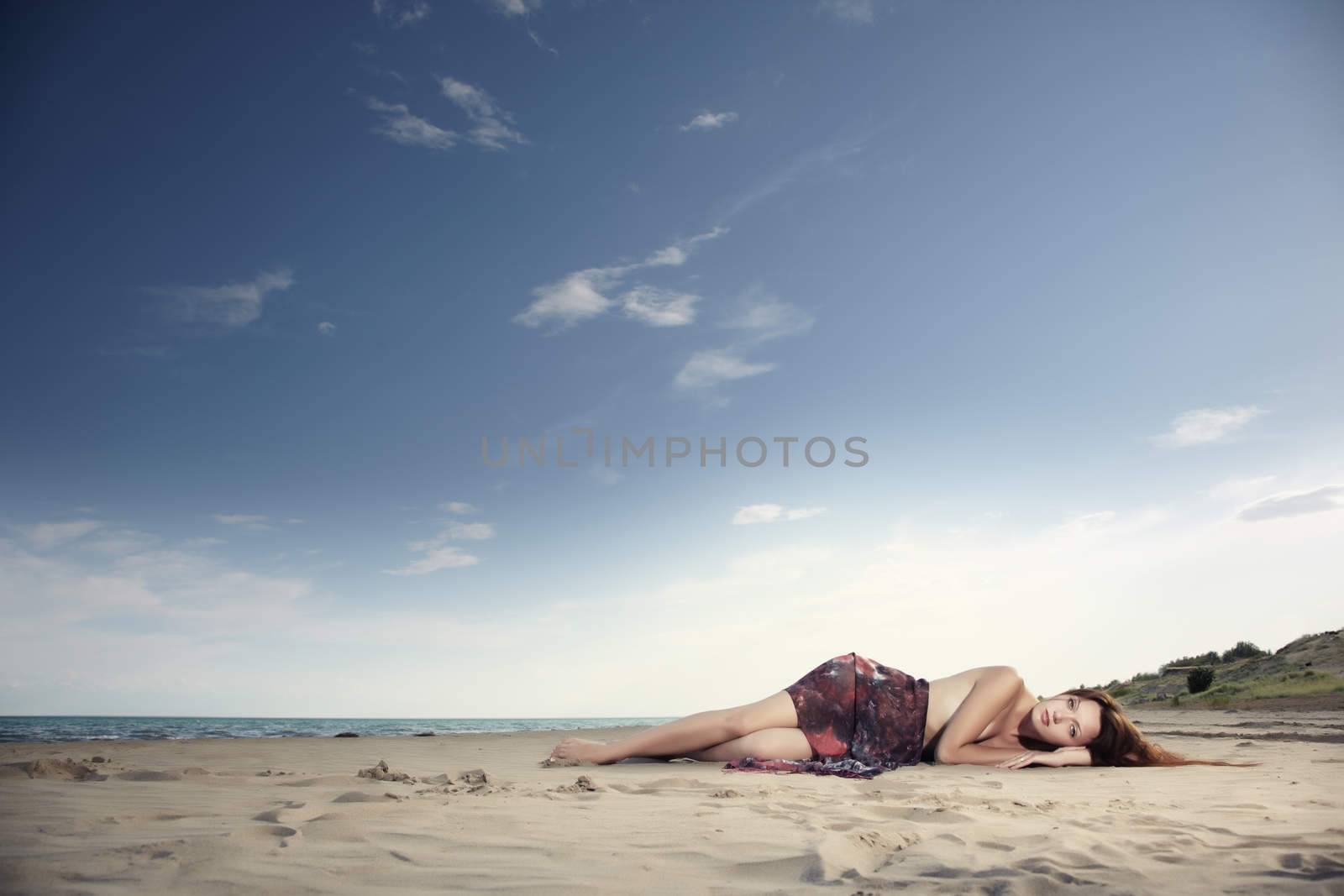 Red hair lady laying at the summer beach