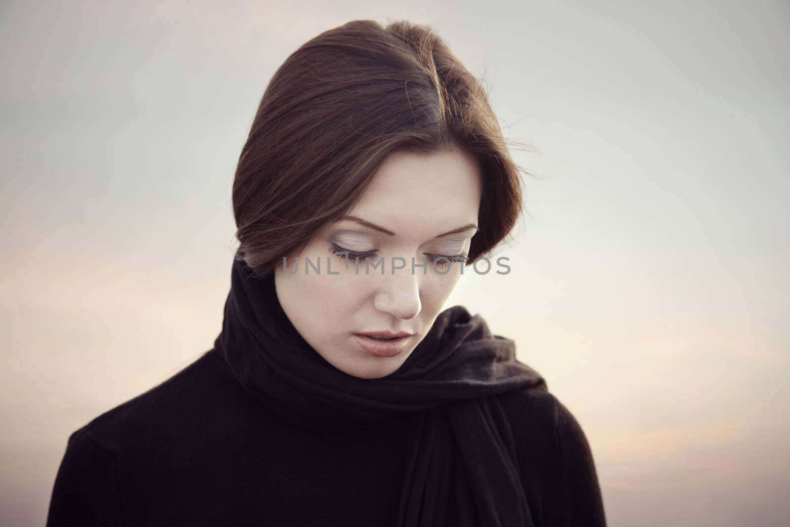 Vintage photo of the sad lady with black belcher at the sunset background