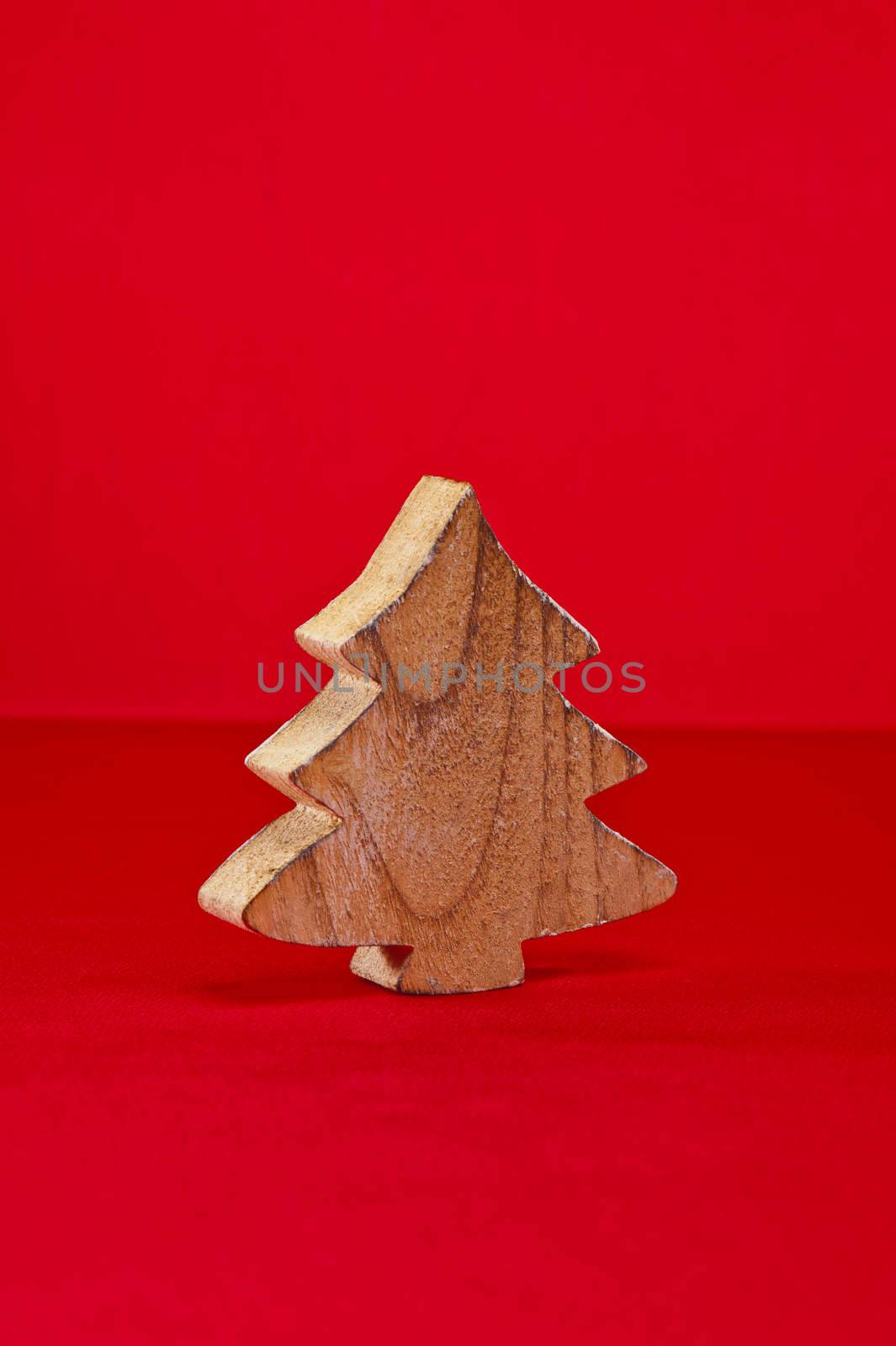 Wood cut shape Christmas tree over red surface