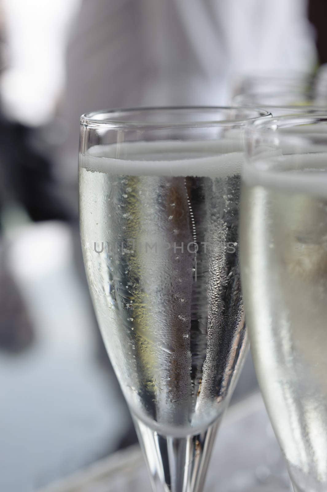 Pouring sparkling beverage on flute glasses