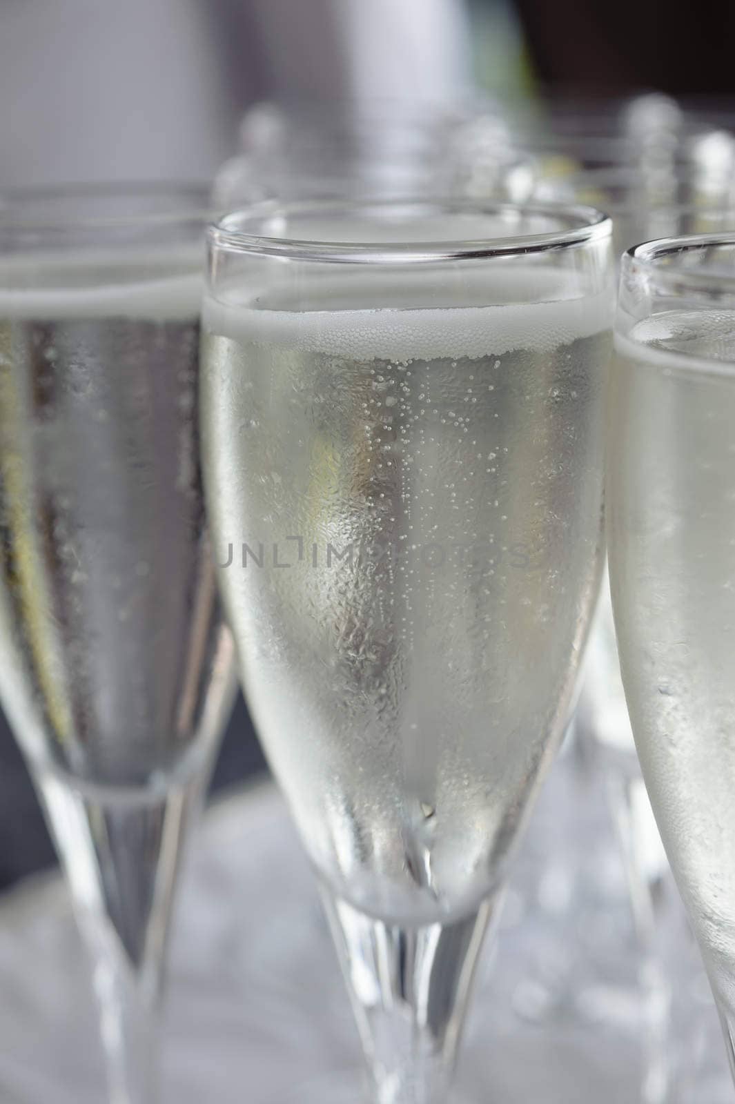 Pouring sparkling beverage on flute glasses