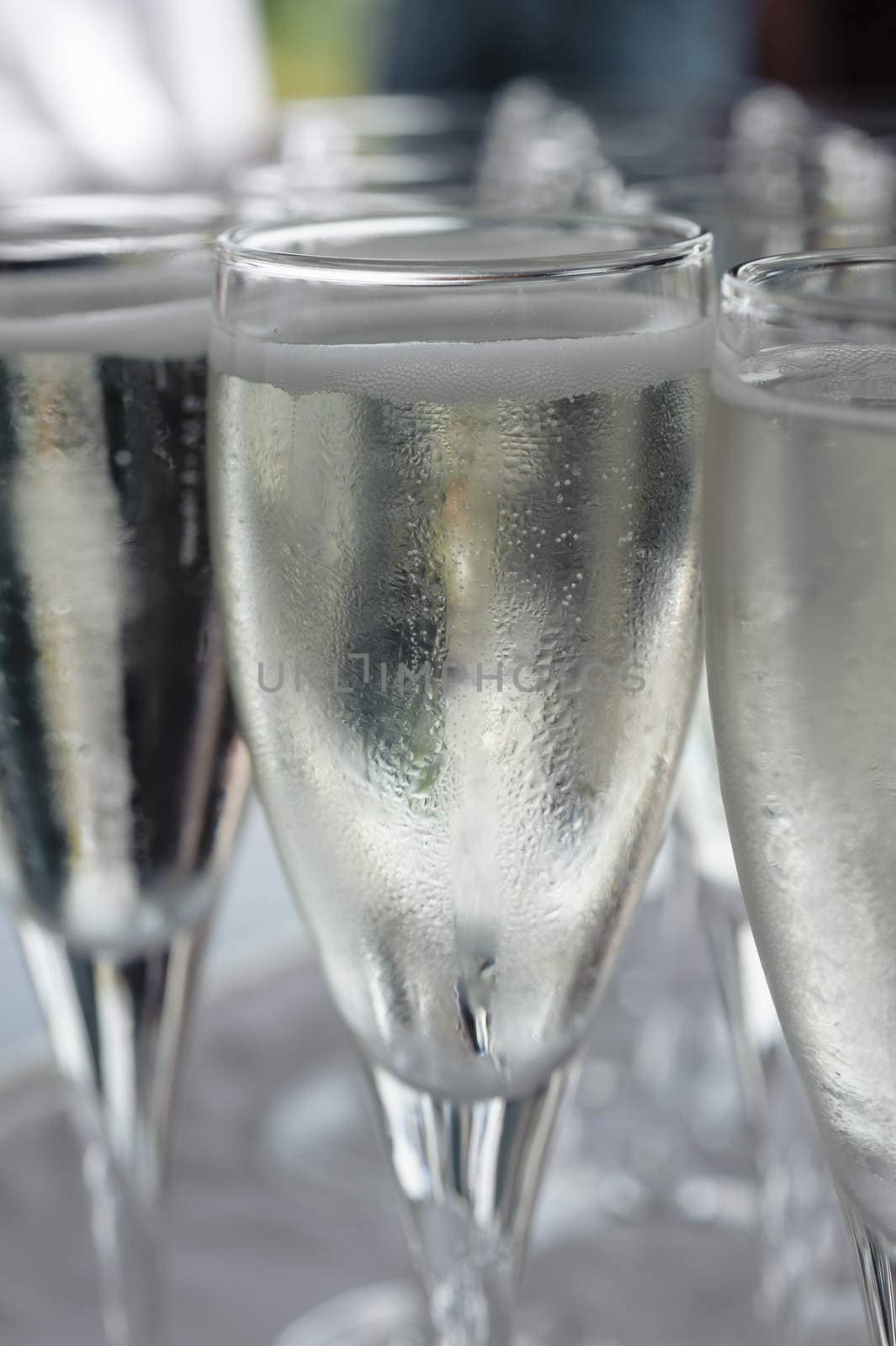 Pouring sparkling beverage on flute glasses