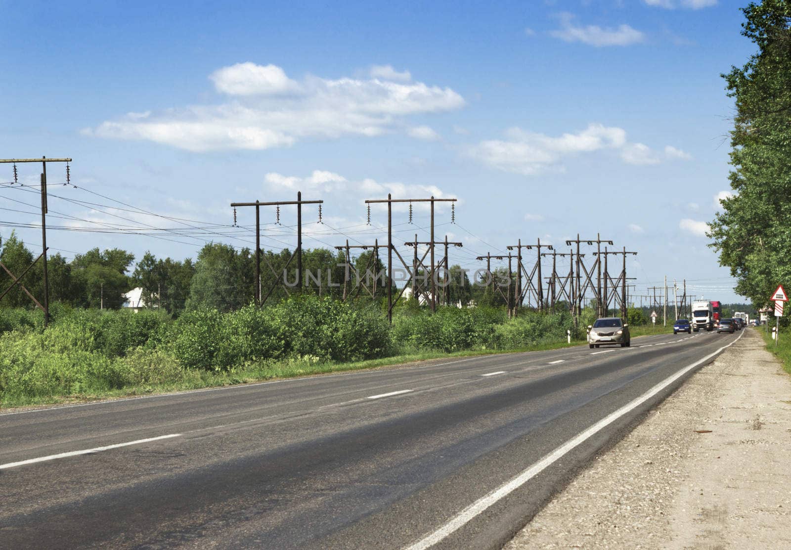 Wooden supports the electrical line along the highway. Russia