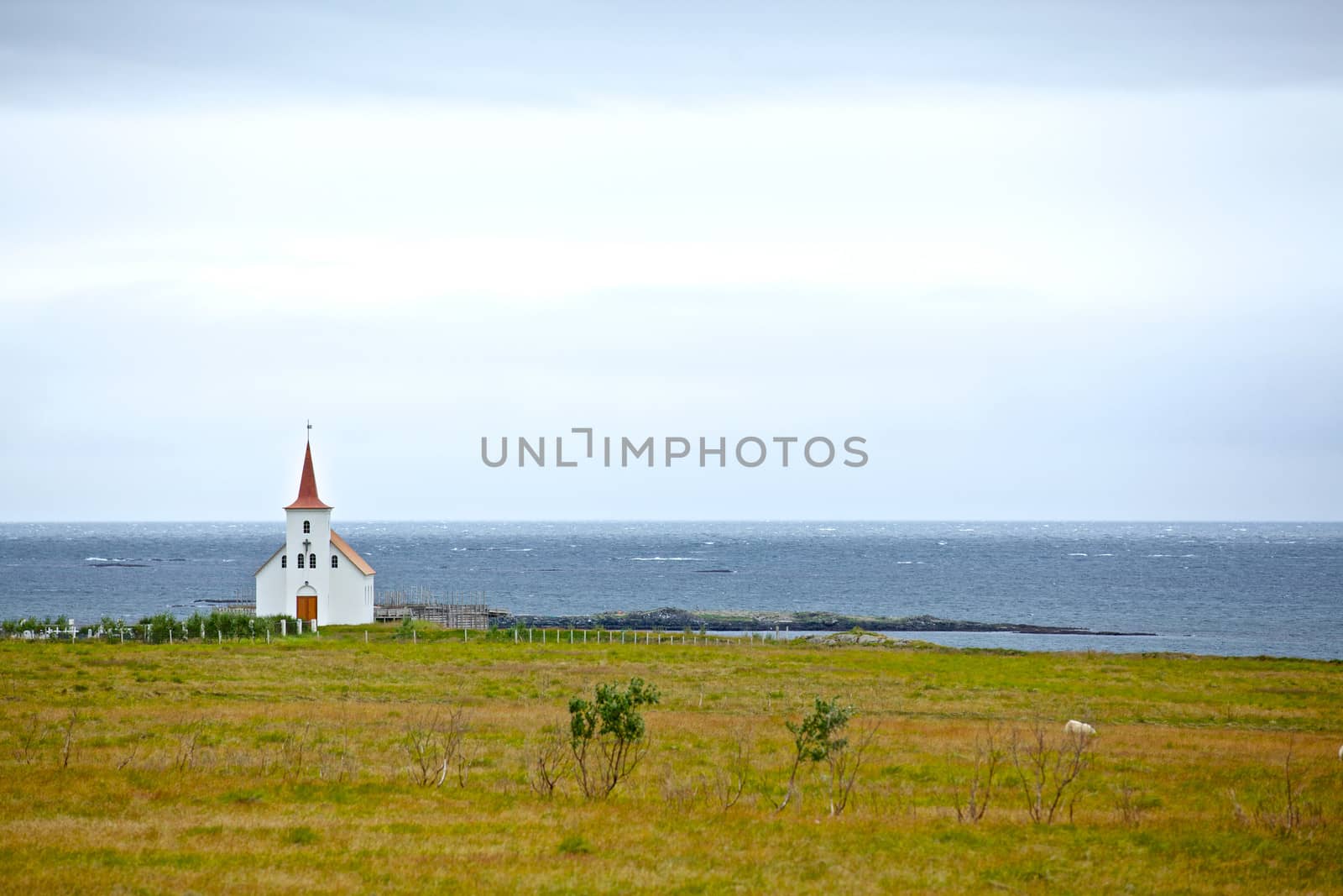 Small white church near the ocean, Iceland. Summer day.