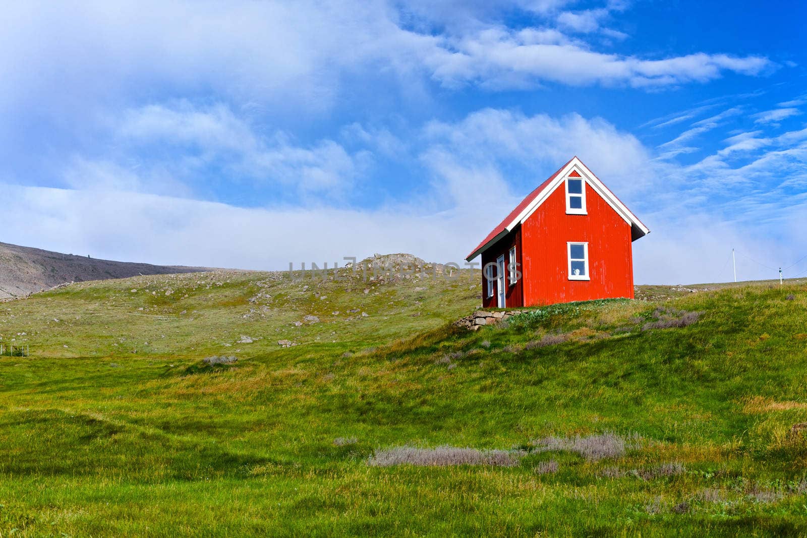 Beautiful red house against the blue sky in Iceland.