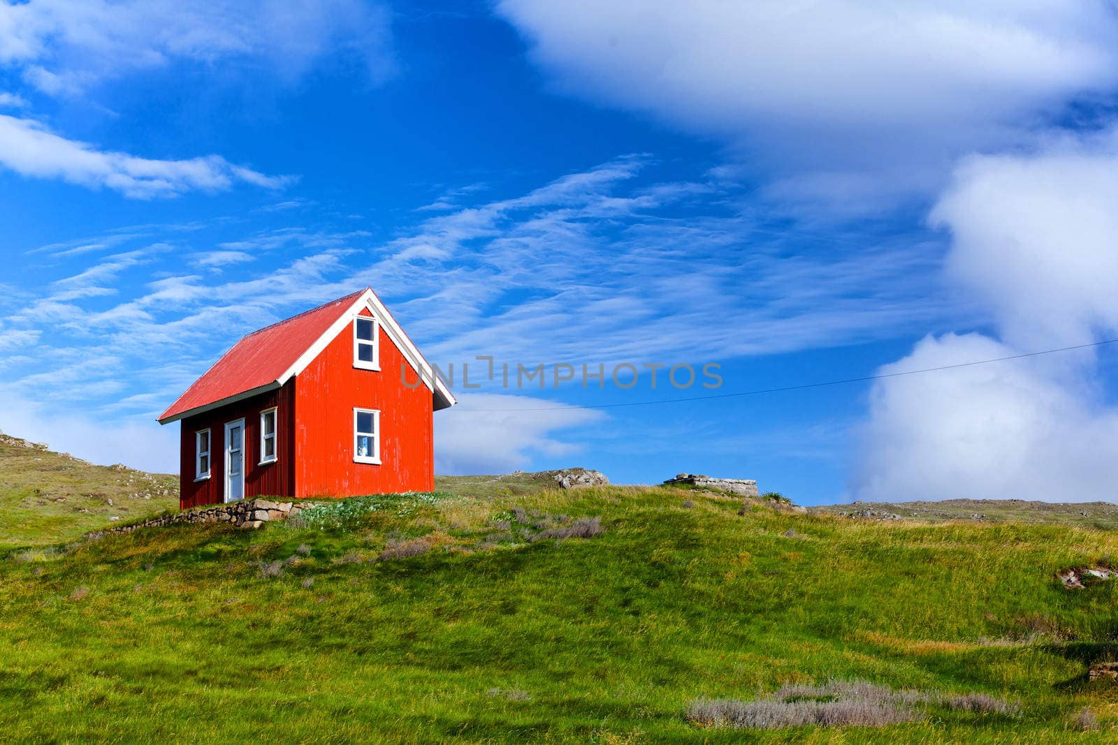 Beautiful red house against the blue sky in Iceland.