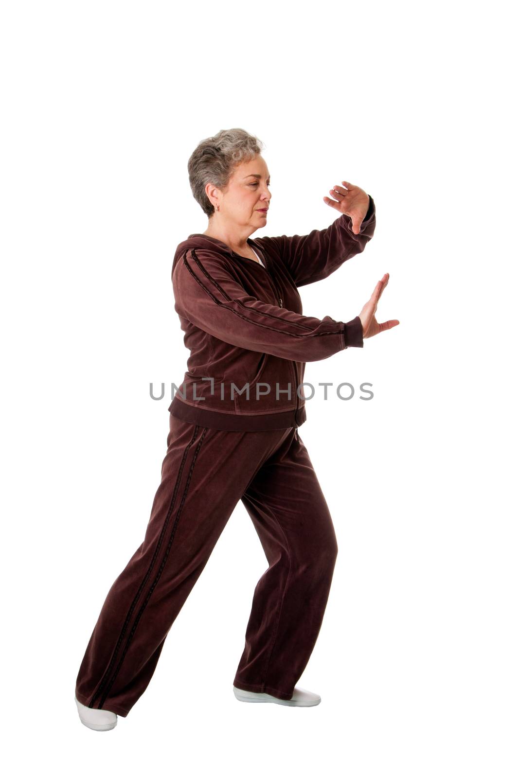 Beautiful Senior woman doing Tai Chi exercise to keep her joints flexible, isolated.
