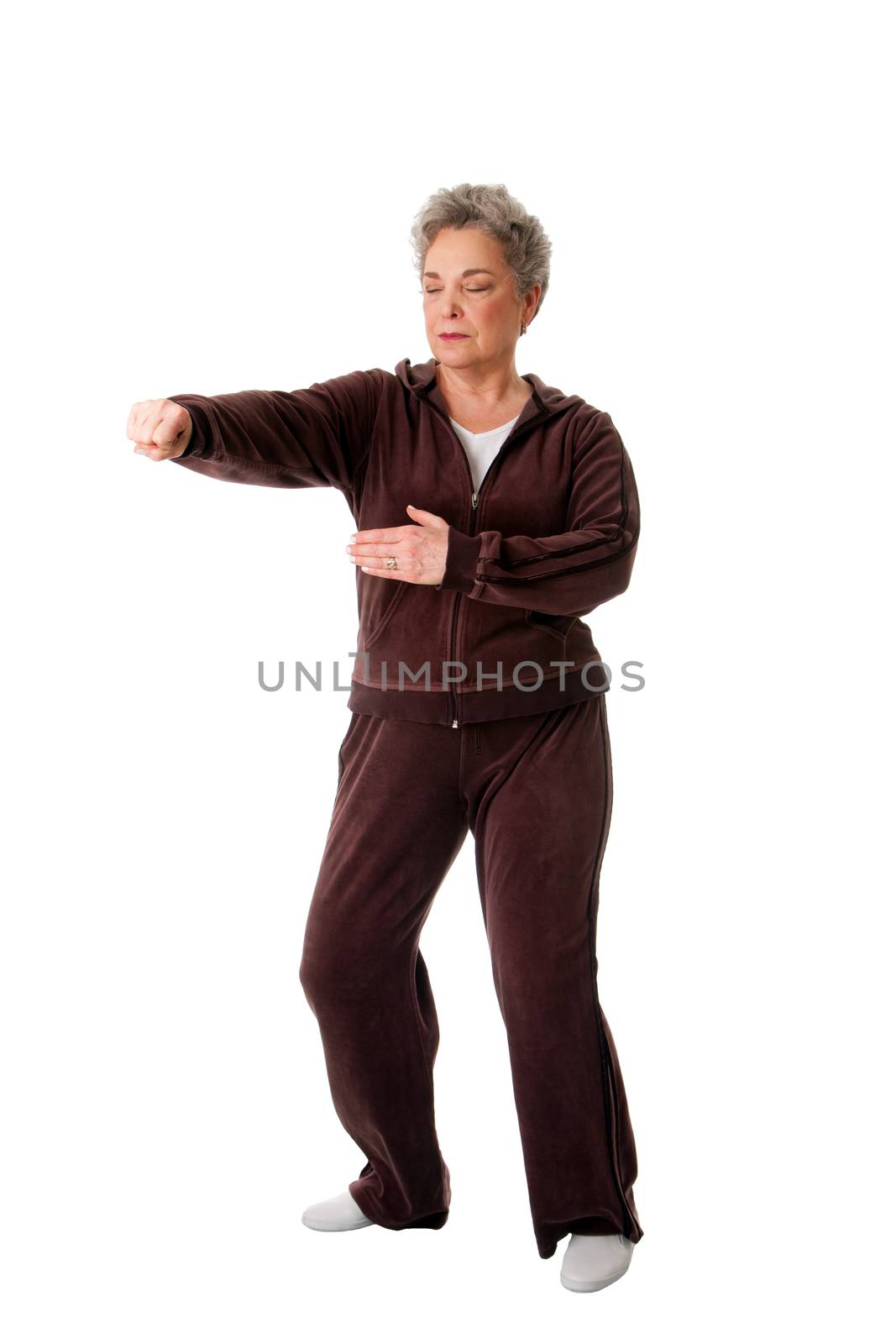 Beautiful Senior woman doing Tai Chi punching exercise to keep her joints flexible, isolated.
