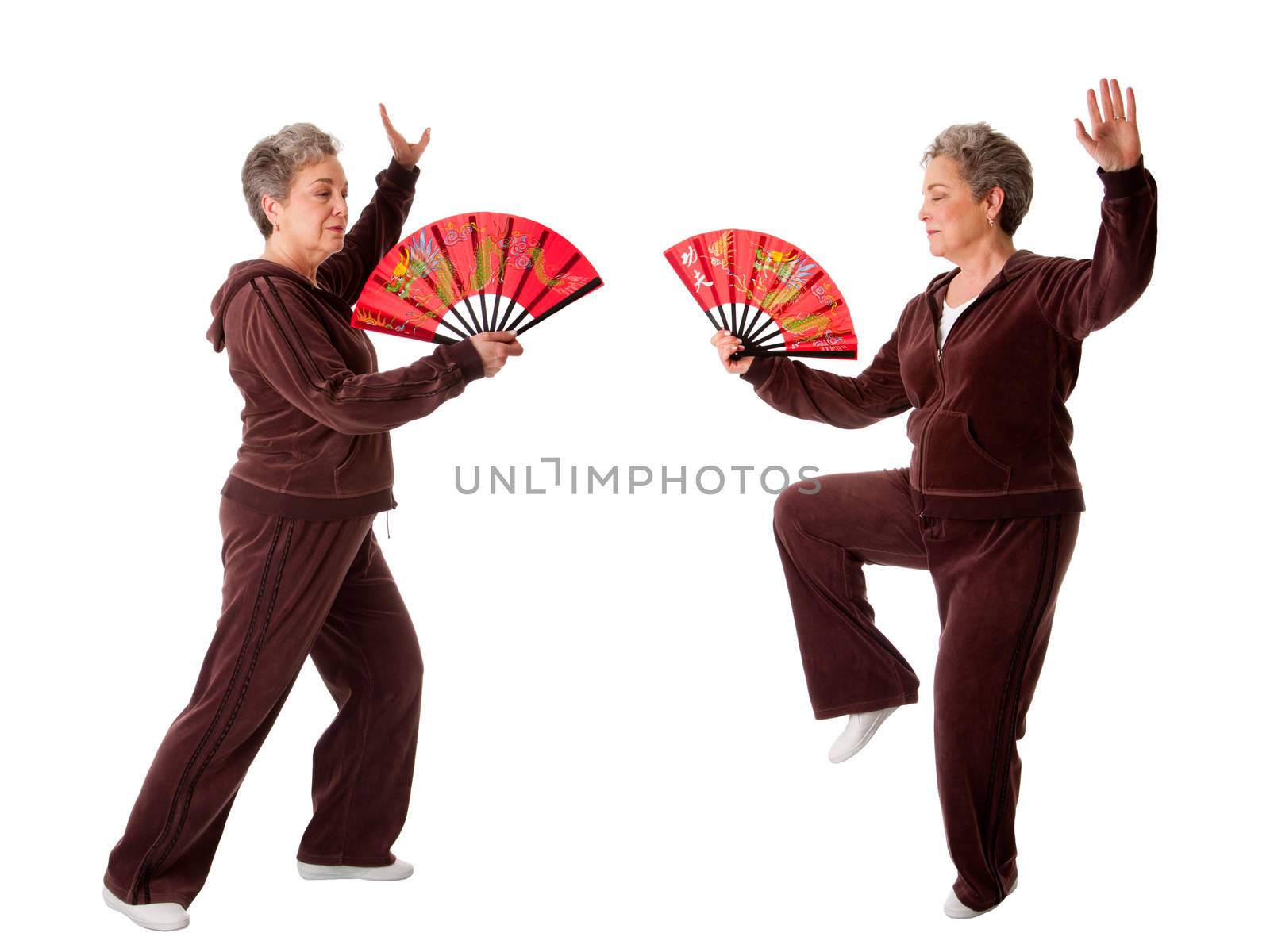 Senior woman doing Tai Chi Yoga exercise by phakimata