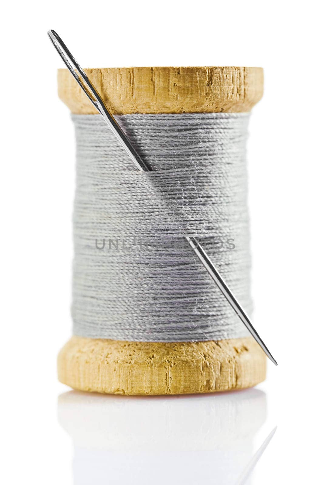spool with gray thread and nidle