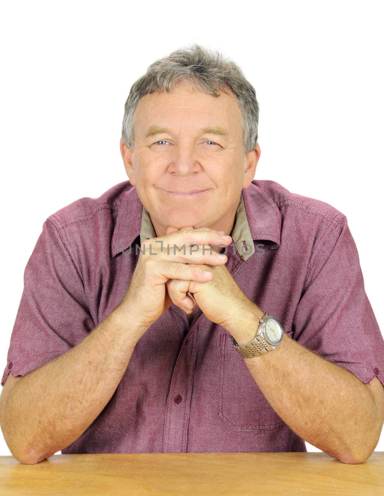 Contented middle aged man seated looking to camera.