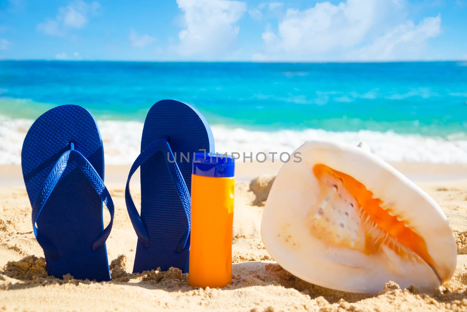 Flip flops and starfish with sunglasses on sandy beach by EllenSmile